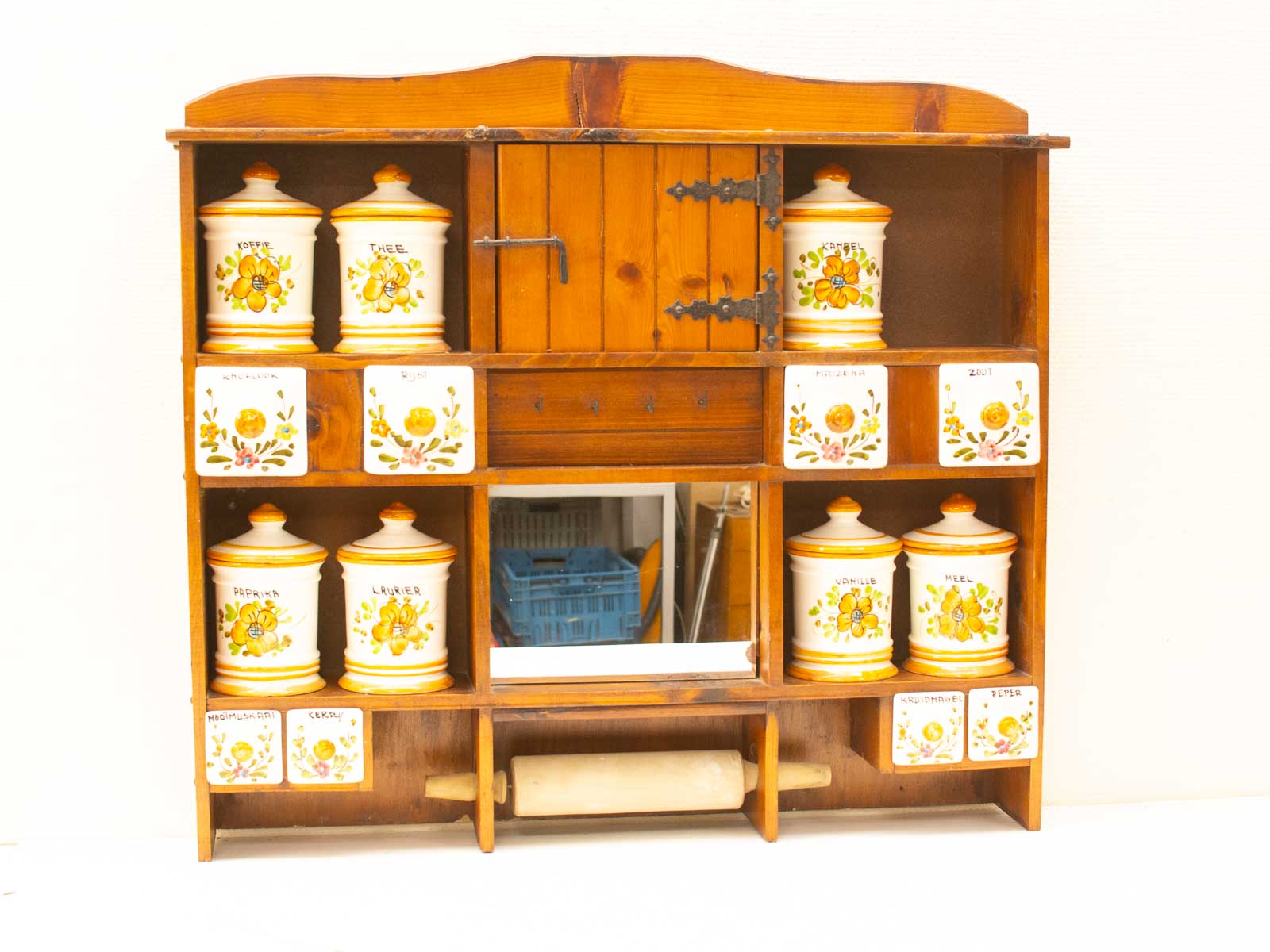 Rustic wooden kitchen shelf with decorative ceramic jars for stylish spice storage.