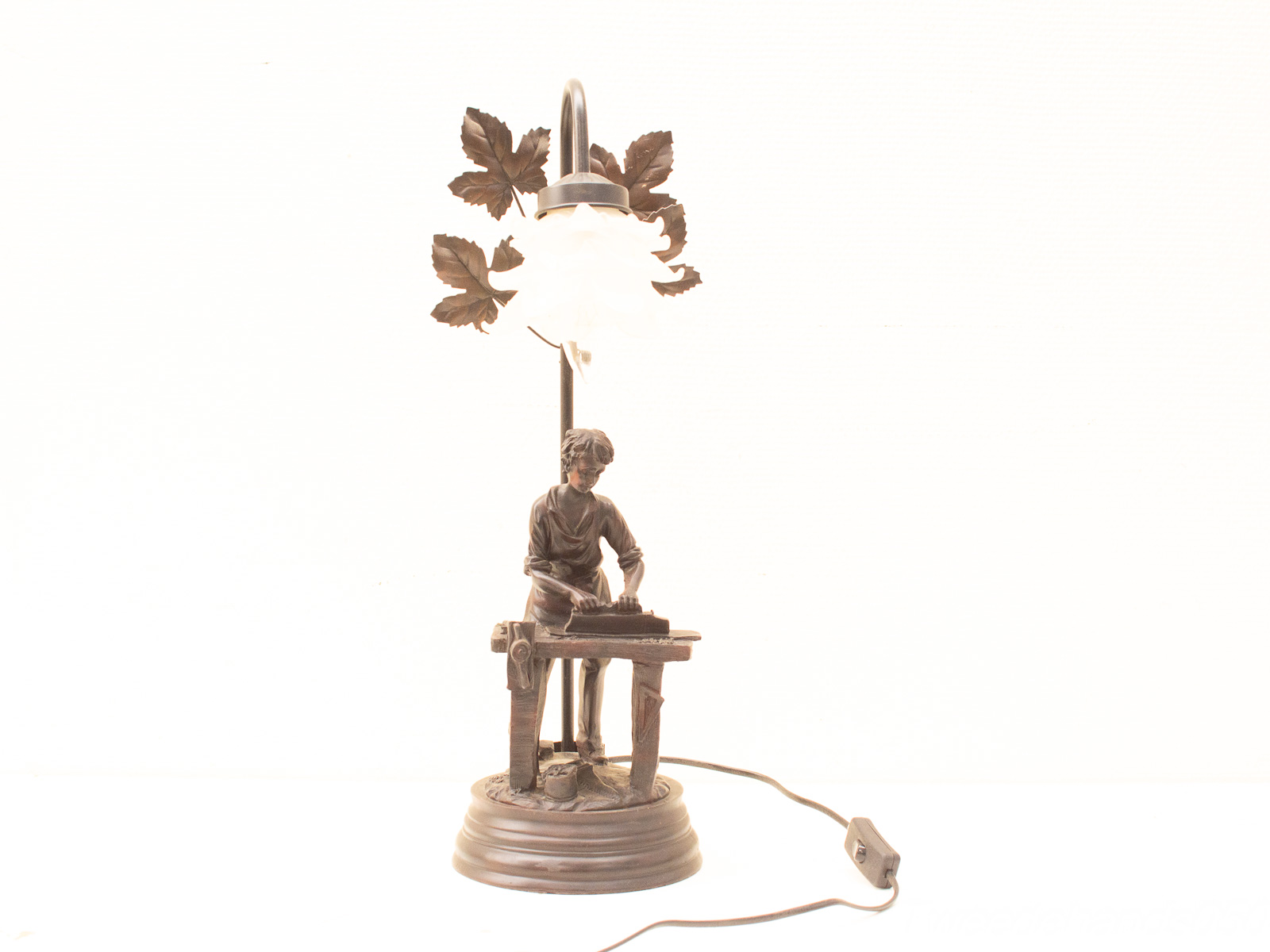 Vintage lamp with boy sculpture and natural leaf details, perfect for cozy, nostalgic spaces.