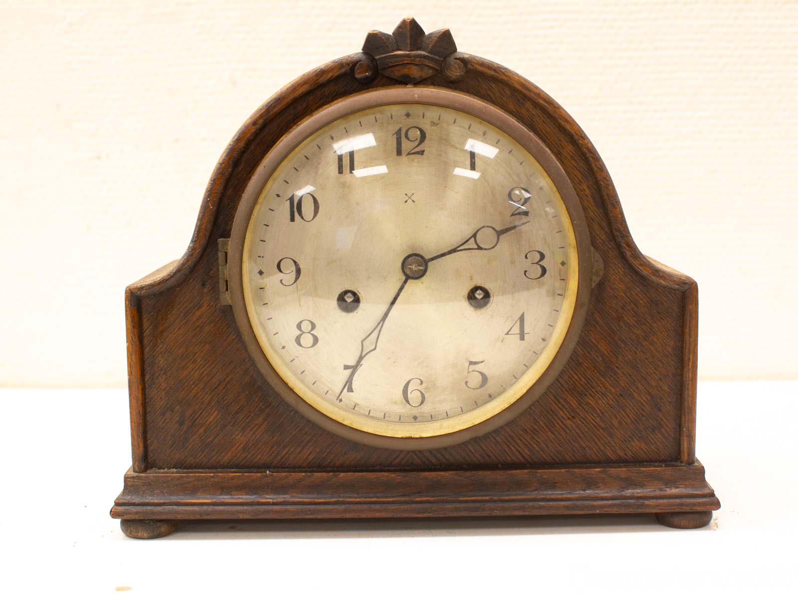 Elegant vintage mantel clock with wooden case, classic design, and charming patina for timeless decor.