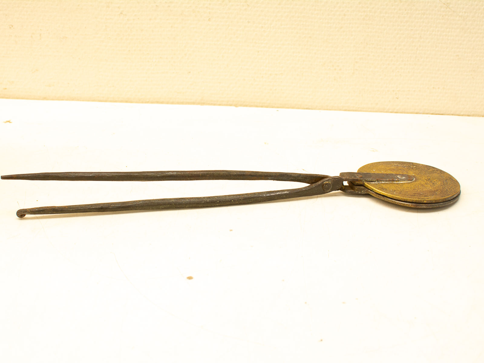 Vintage measuring tool with brass disc and dark metal arms, showcasing craftsmanship and history.