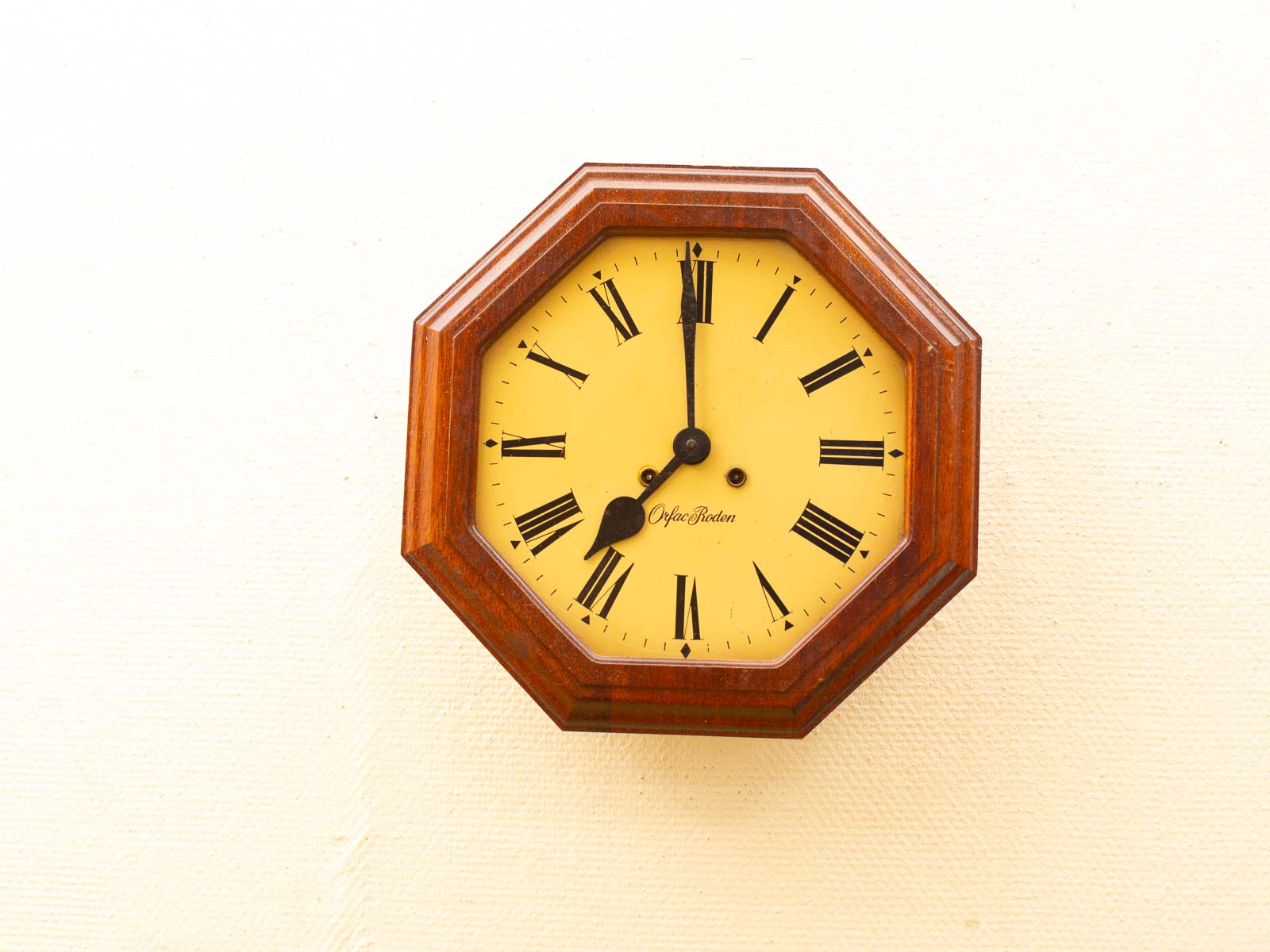 Vintage wooden octagonal wall clock with Roman numerals and elegant design, perfect for classic decor.