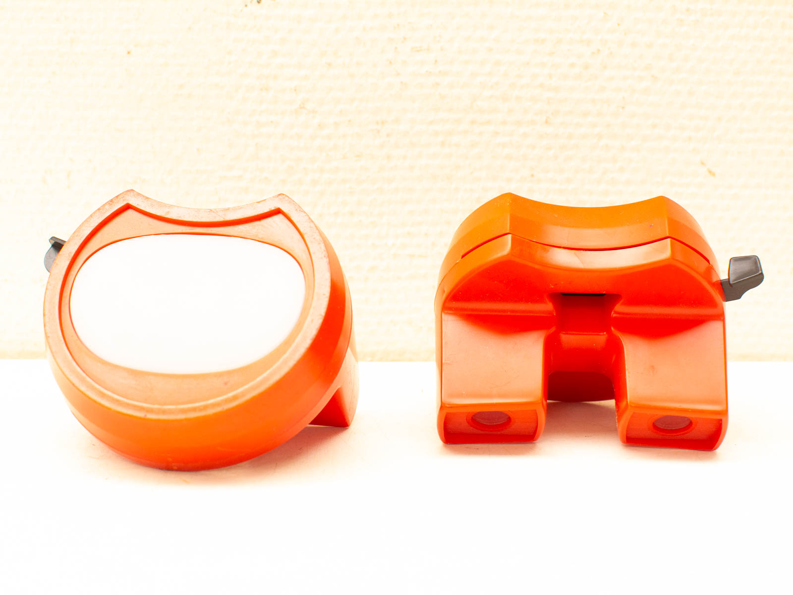 Vintage orange measuring tools on a textured white background, highlighting their stylish design and functionality.