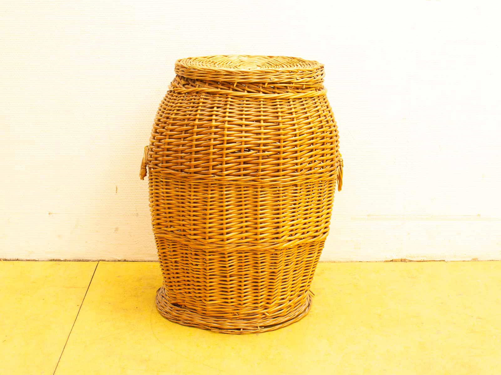 Stylish barrel-shaped wicker basket for decorative storage, featuring intricate weaving and a snug lid.