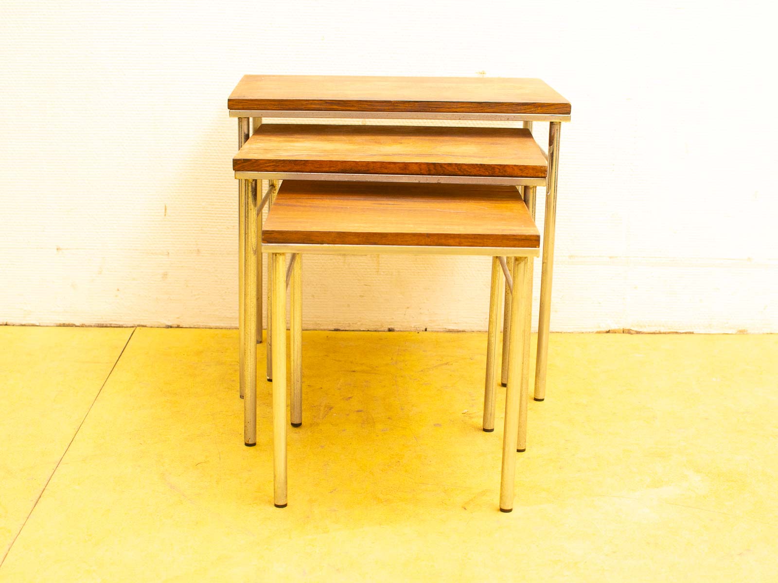 Elegant wooden nesting tables with sleek metal legs, perfect for versatile, modern living spaces.