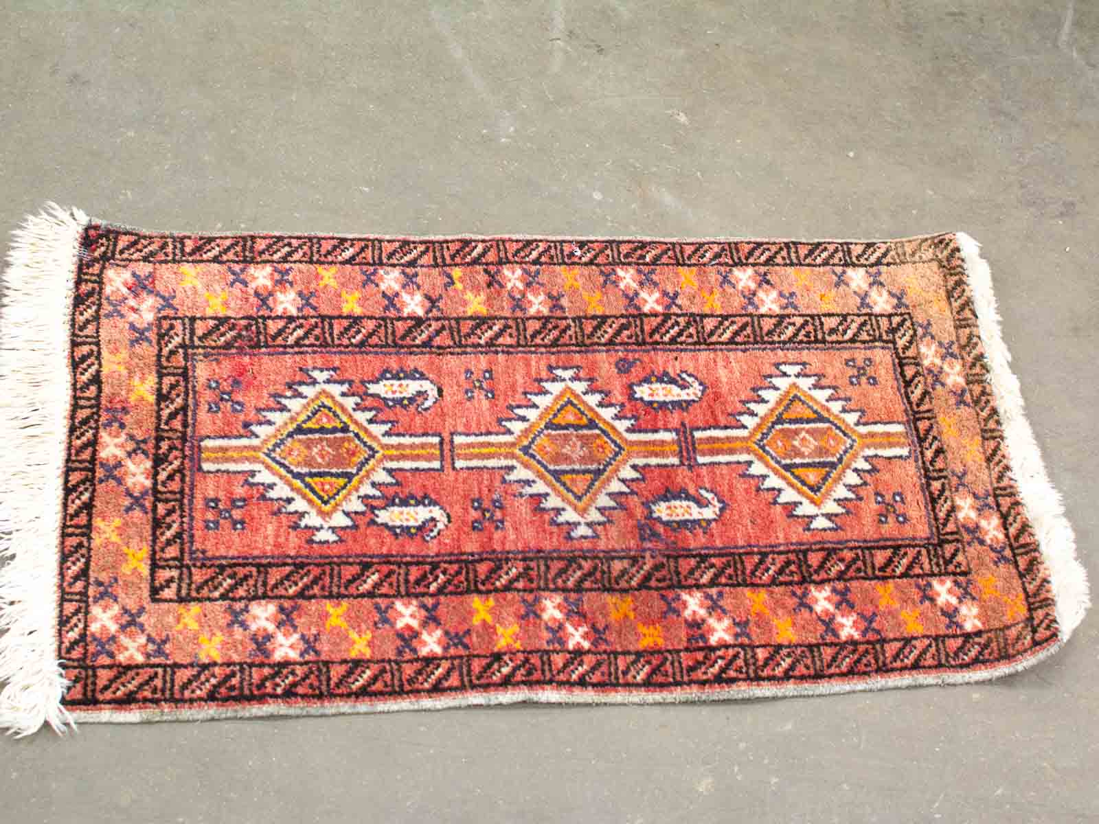 Vibrant terracotta geometric rug with fringes, adding warmth and cultural charm to your decor.