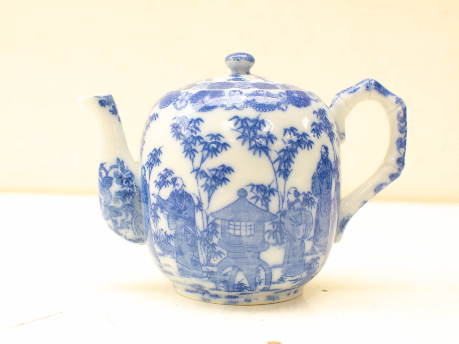 Elegant hand-painted blue and white teapot with intricate nature motifs, perfect for collectors.