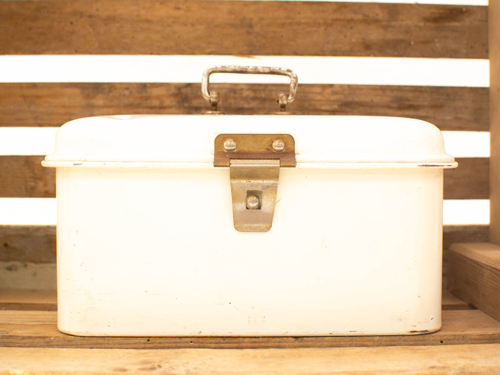 Nostalgic vintage white metal box with rounded top, handle, and latch for charming storage.