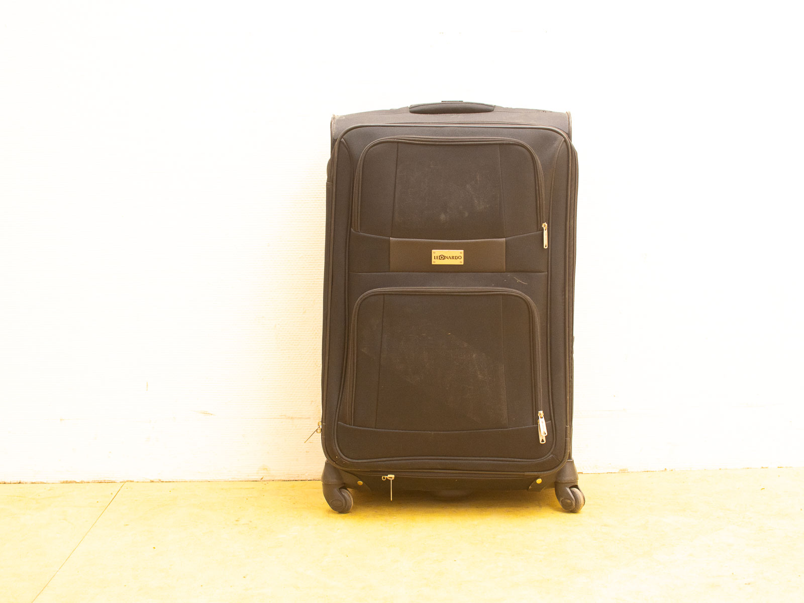 Vintage black suitcase with wheels, featuring zippered compartments and durable design for adventurous travel.