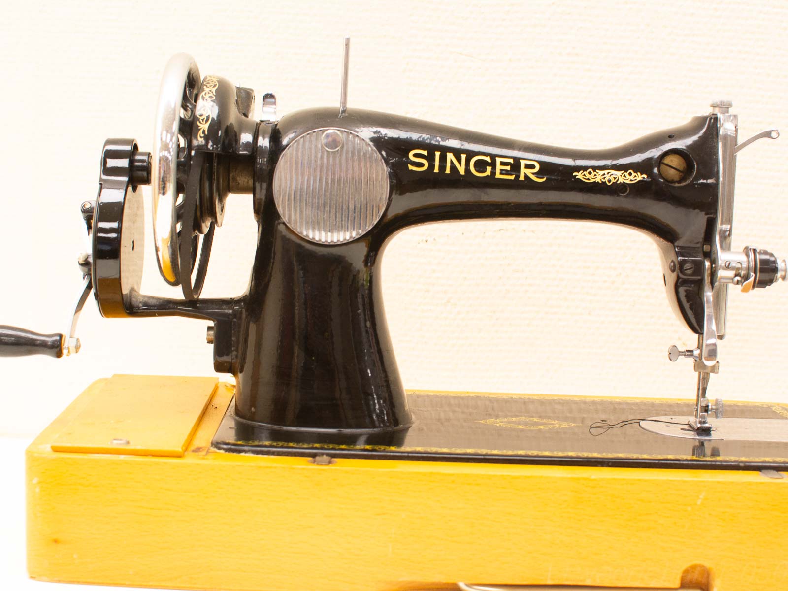 Classic vintage Singer sewing machine on a warm wooden table, embodying nostalgia and craftsmanship.