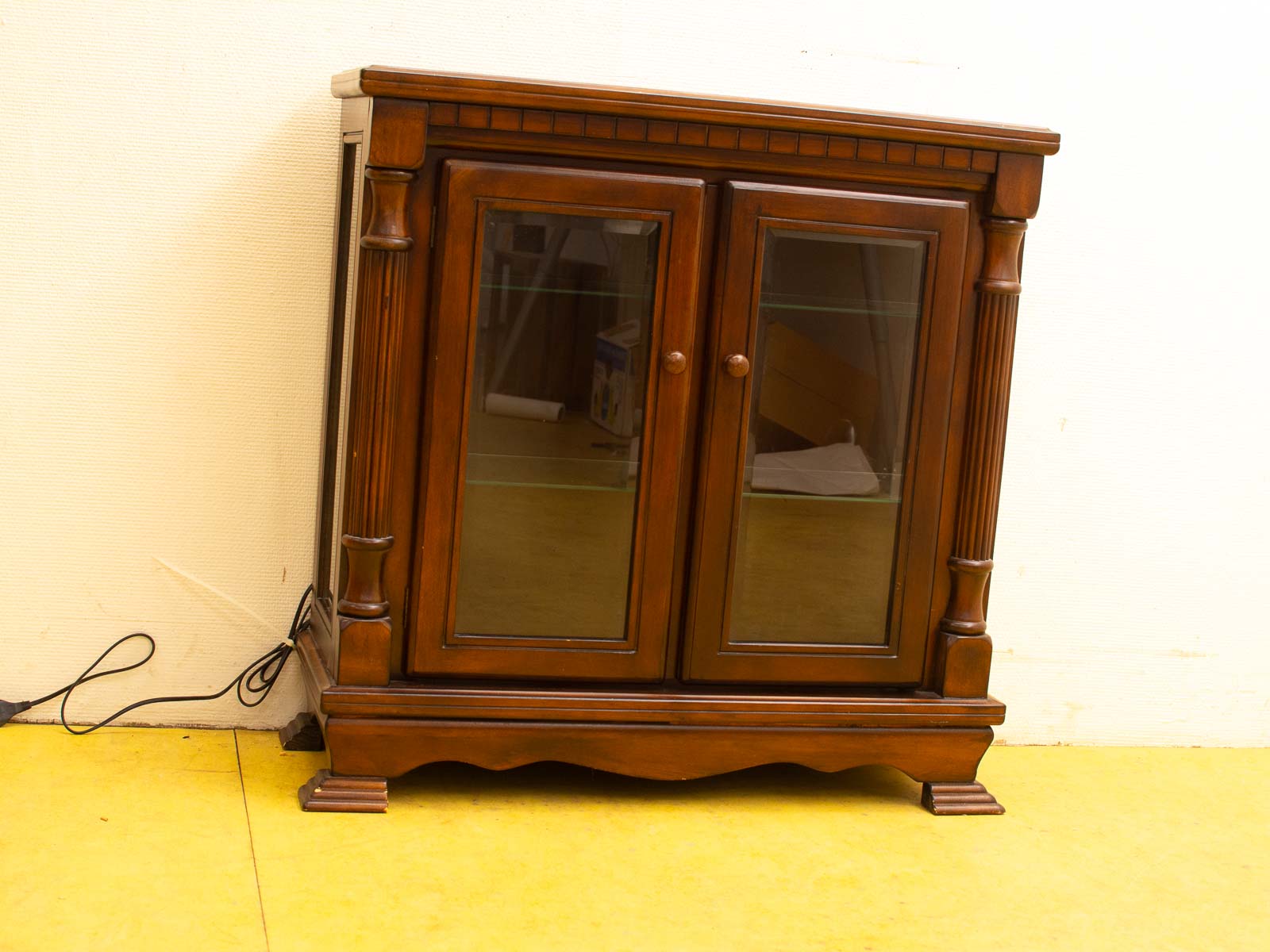 Elegant vintage wooden cabinet with glass doors, perfect for stylish storage and display.