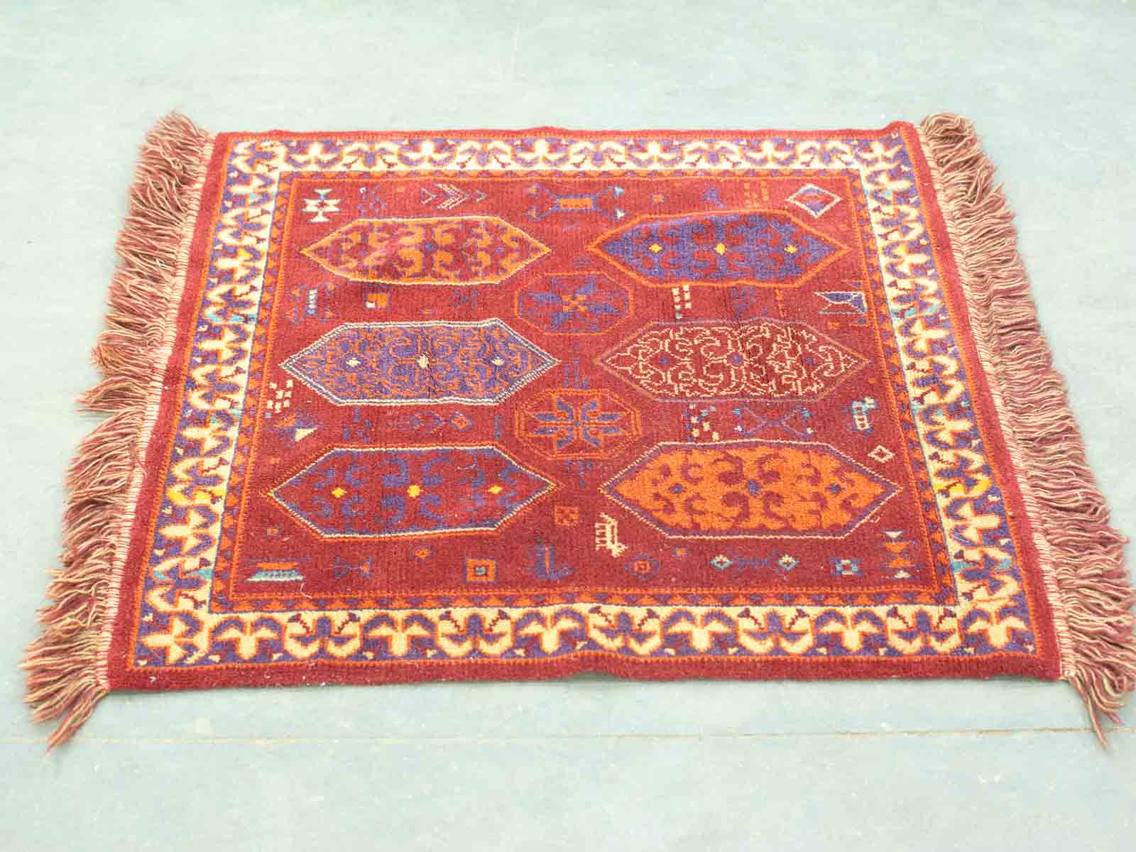 Vibrant vintage rug featuring intricate diamond patterns and rich, contrasting colors for stunning decor.