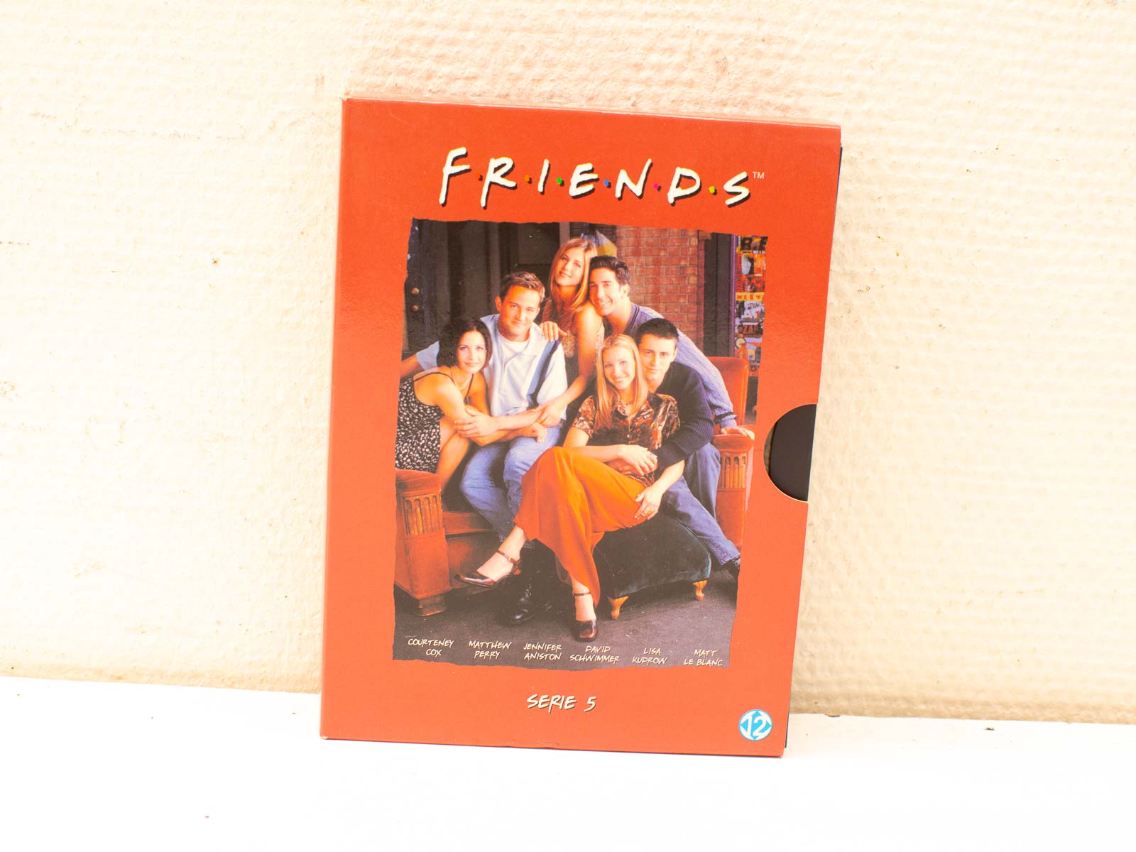 Vibrant red DVD cover of Friends Season 5, featuring beloved characters and vintage nostalgia.