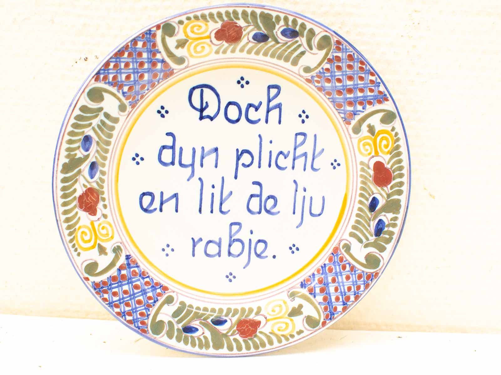 Colorful hand-painted decorative plate with whimsical inscription, perfect for display and cultural appreciation.