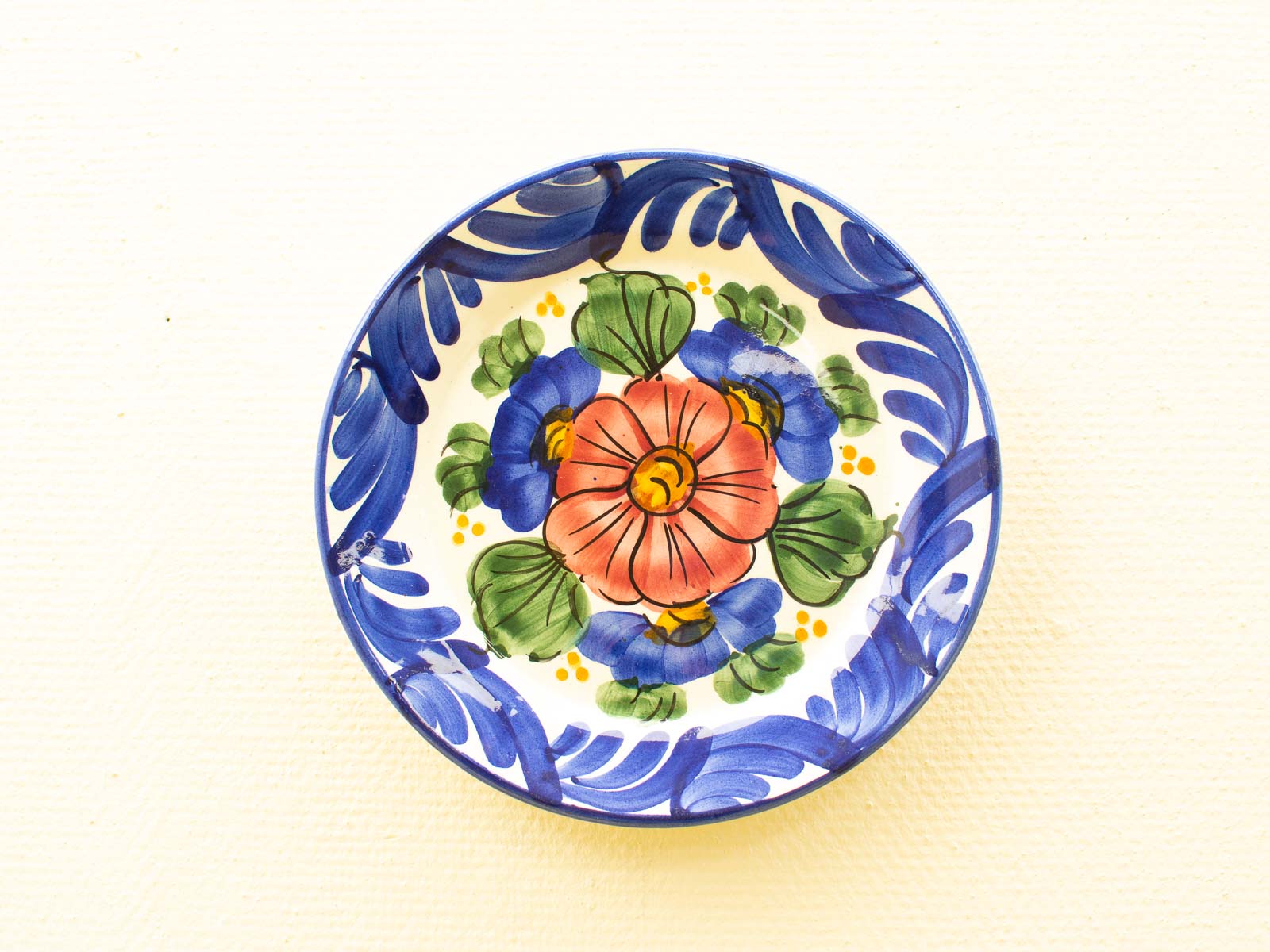 Colorful floral ceramic plate with pink and blue flowers, ideal for decor or dining.