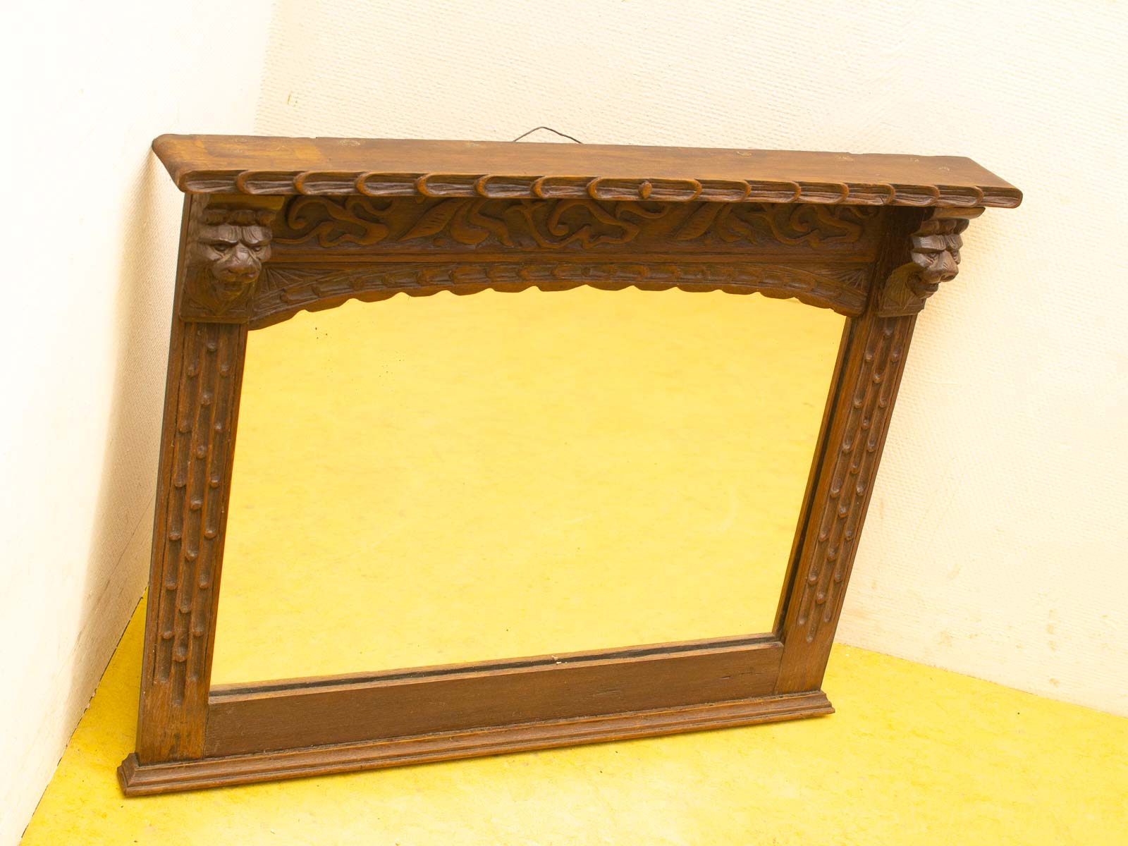 Antique wooden mirror with ornate lion head carvings, perfect for elegant home decor.