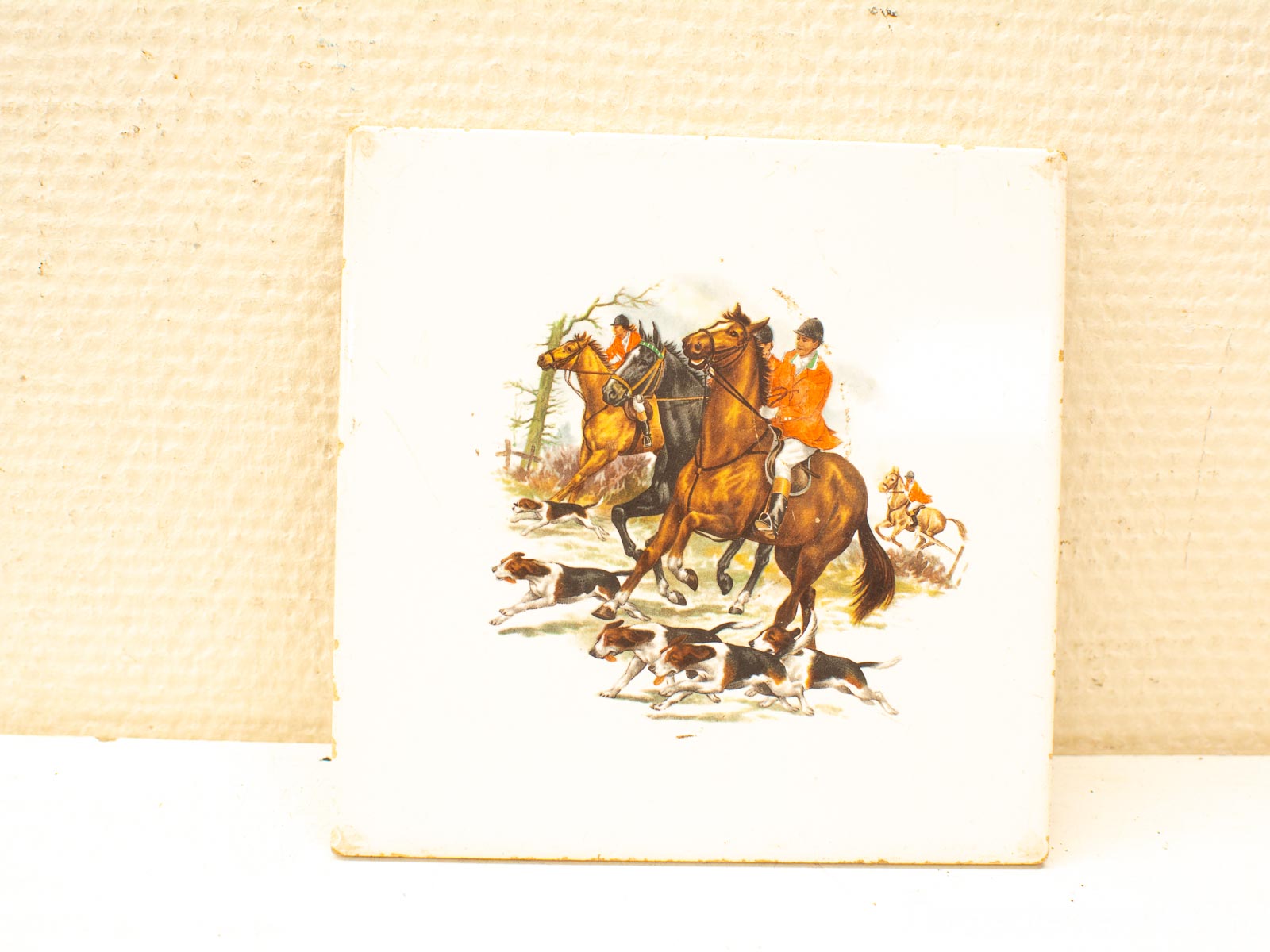 Vibrant hunting scene with riders in orange jackets and energetic dogs in a lush forest.