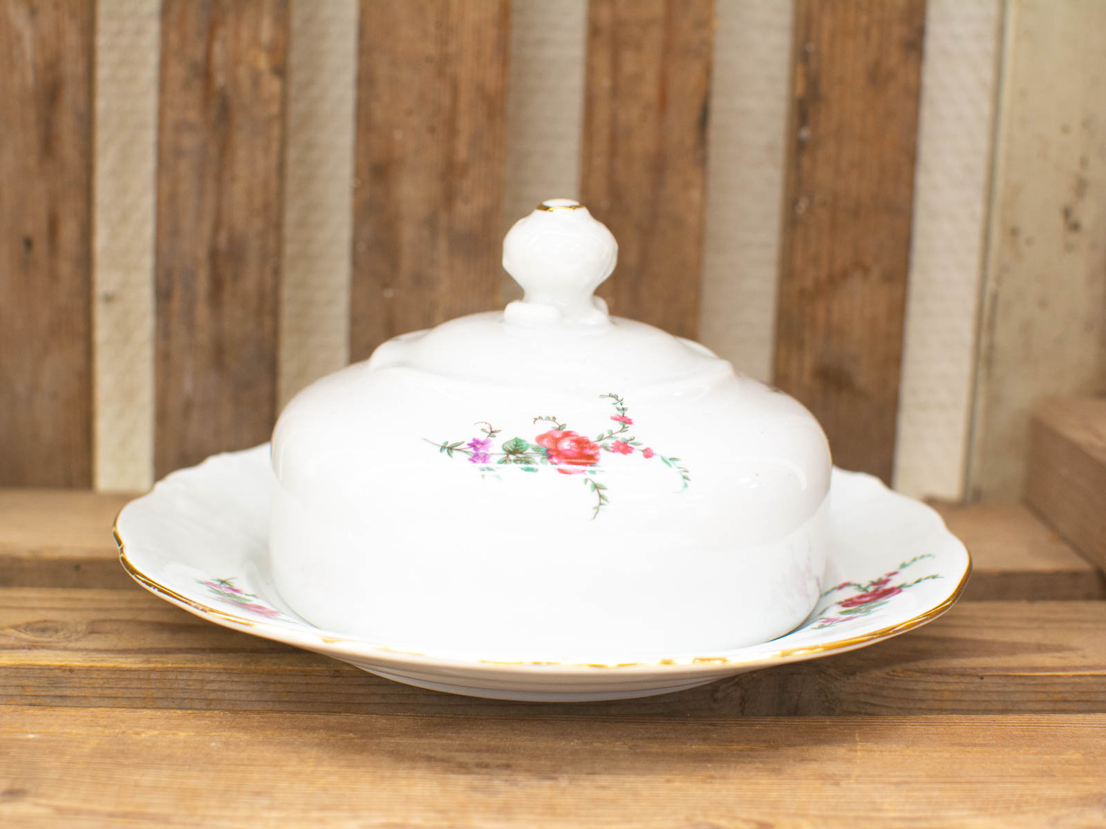 Elegant porcelain butter dish with hand-painted floral design and gold trim, perfect for collectors.