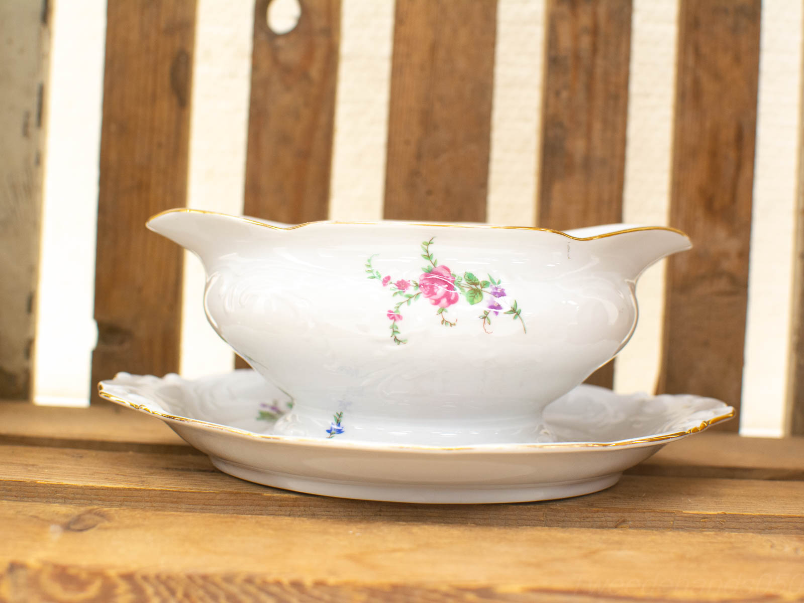 Elegant porcelain sauceboat with floral design and gold rim, perfect for vintage dining experiences.