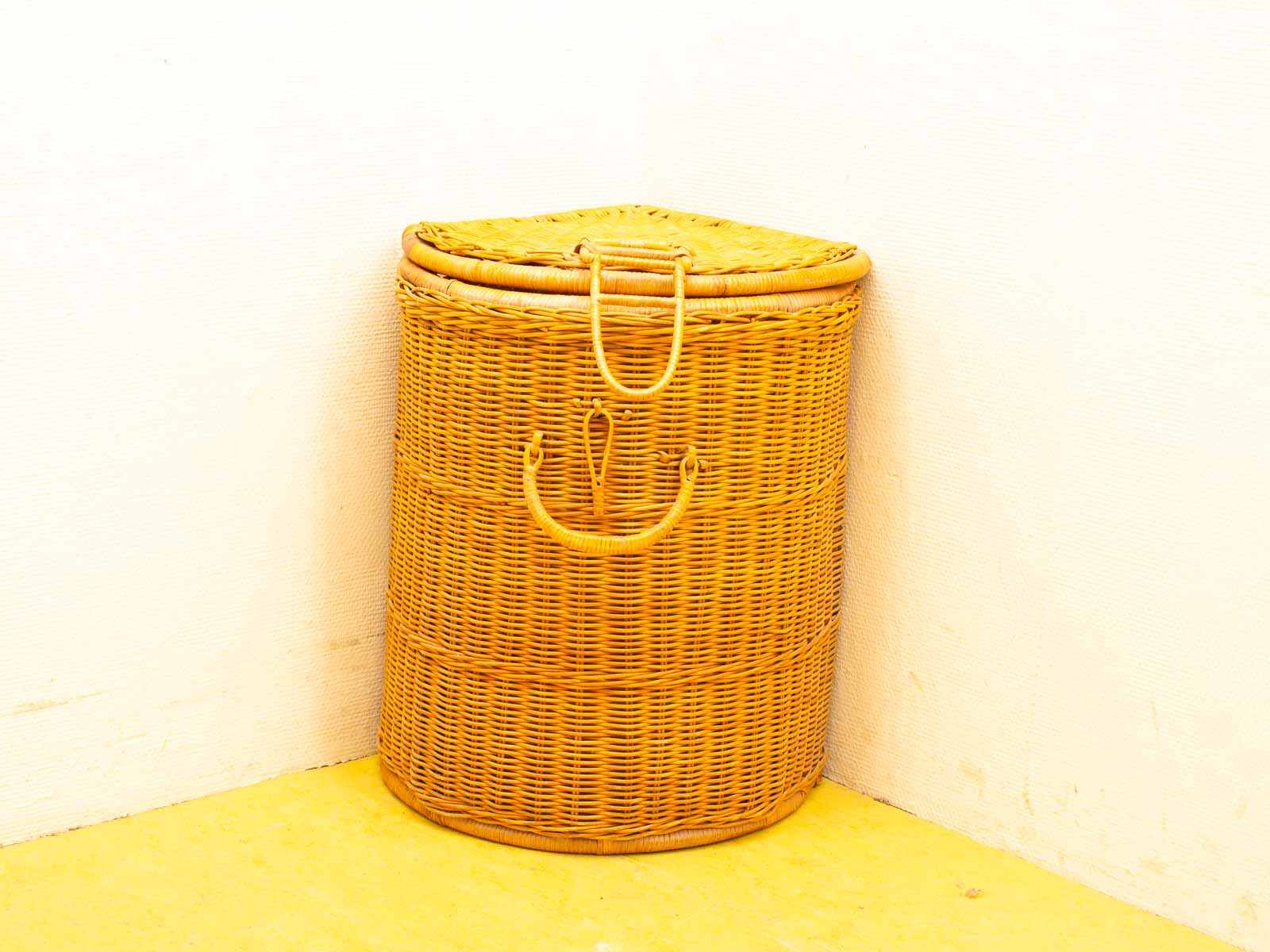 Charming wicker basket in golden hue, perfect for cozy corner home decor.