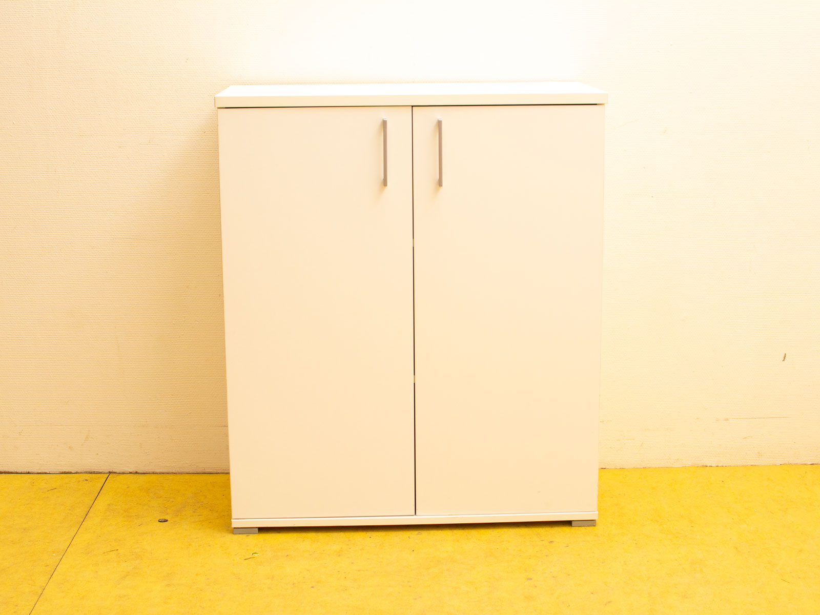 Sleek white cabinet with minimalist design, metallic handles, perfect for any modern space.