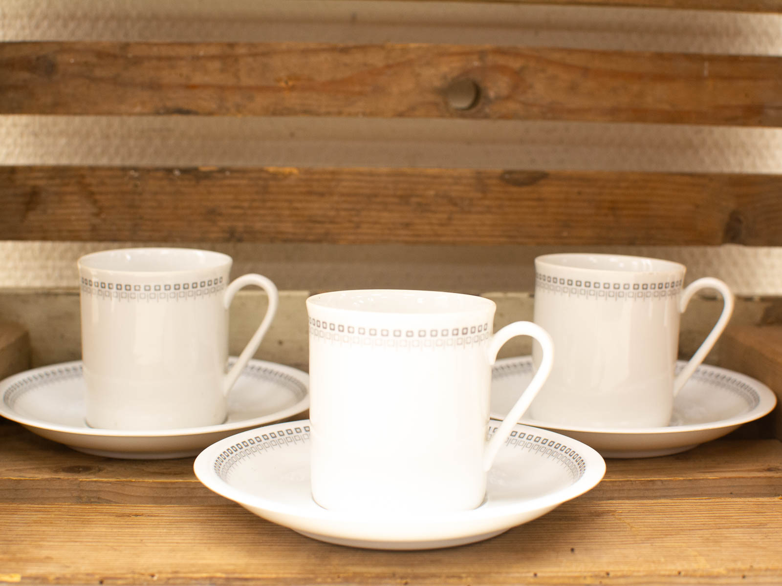 Elegant white cups and saucers on rustic wood, perfect for any gathering.