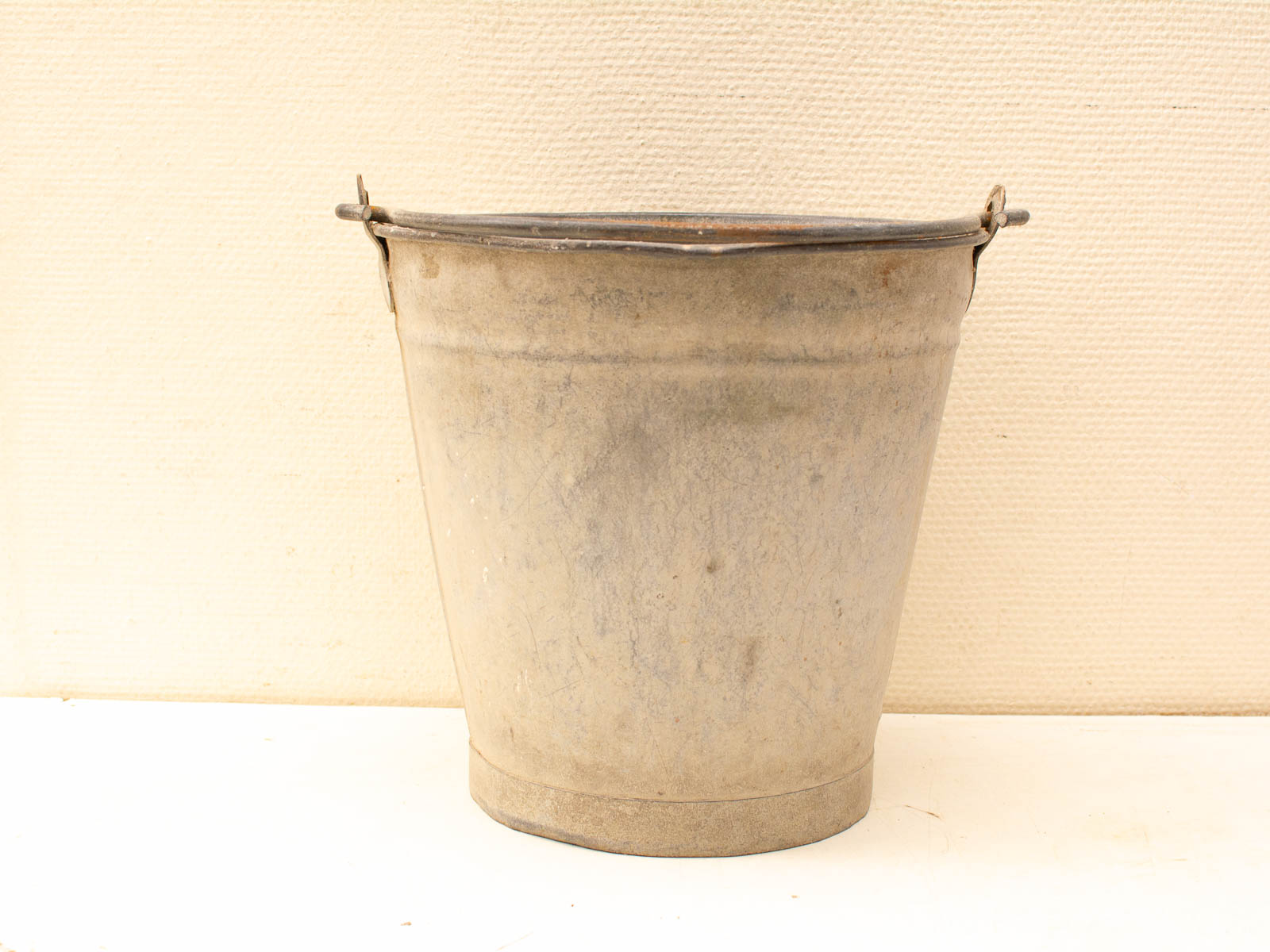 Weathered vintage metal bucket with rustic charm and sturdy handle for functional decor.