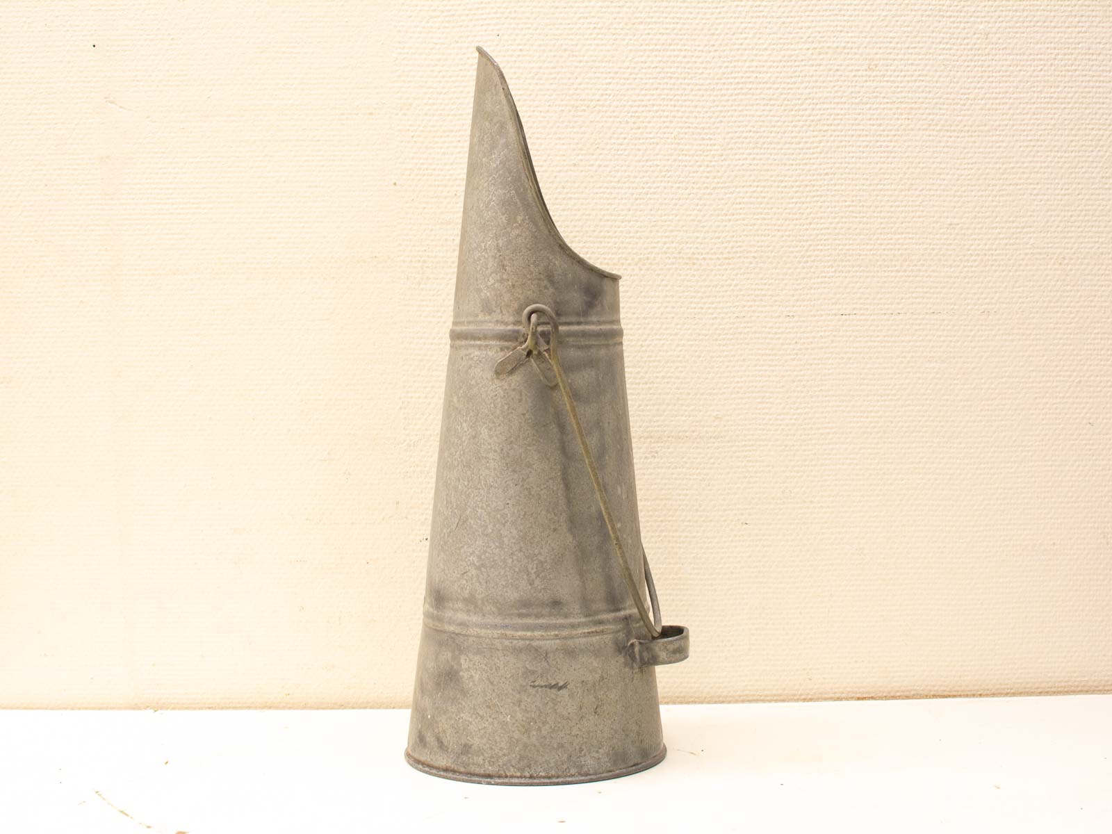 Antique conical tin funnel with wire loop, ideal for décor and practical use.