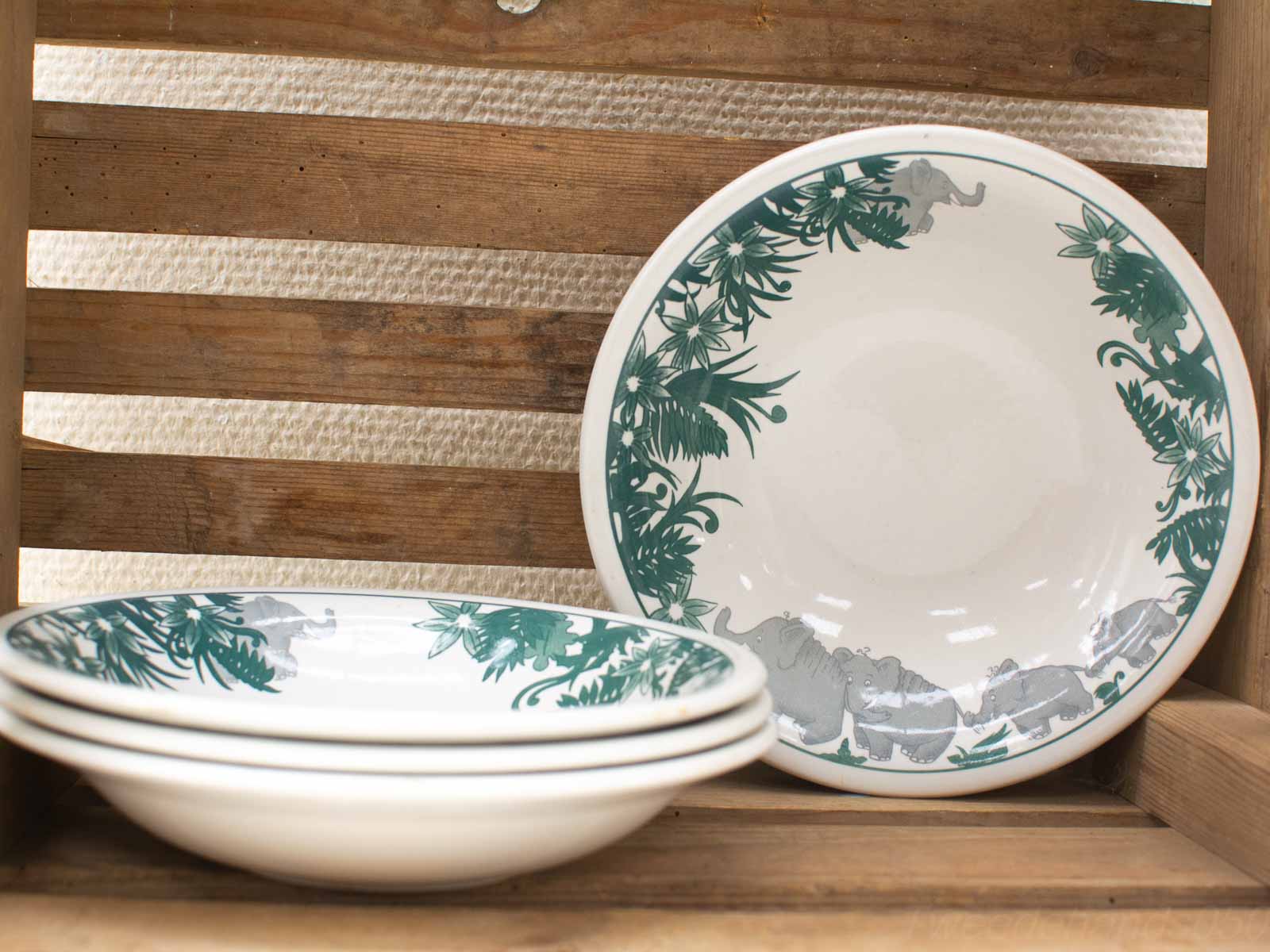 Vintage elephant jungle bowls on a rustic shelf, perfect for charming dining experiences.