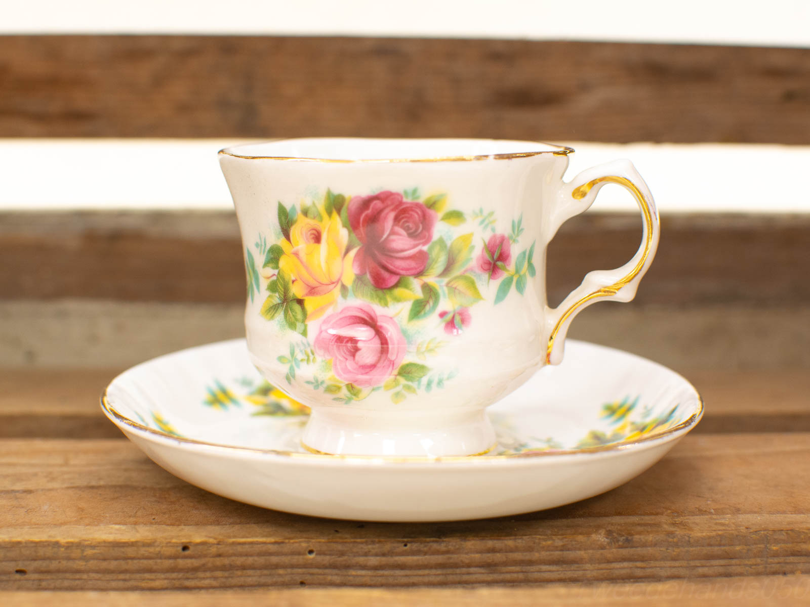 Elegant porcelain teacup and saucer with vibrant floral design and gold trim, perfect for tea.