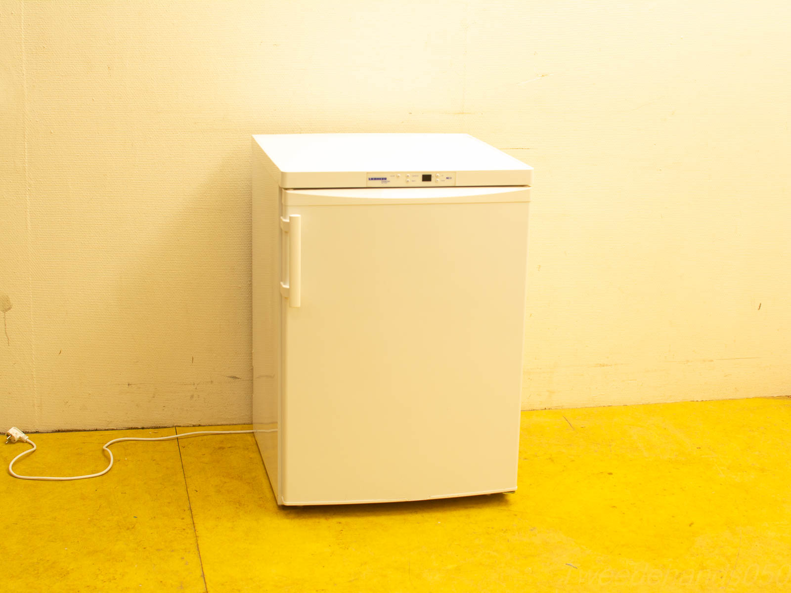 Modern White Compact Refrigerator in Minimalist Setting, Ready for Use