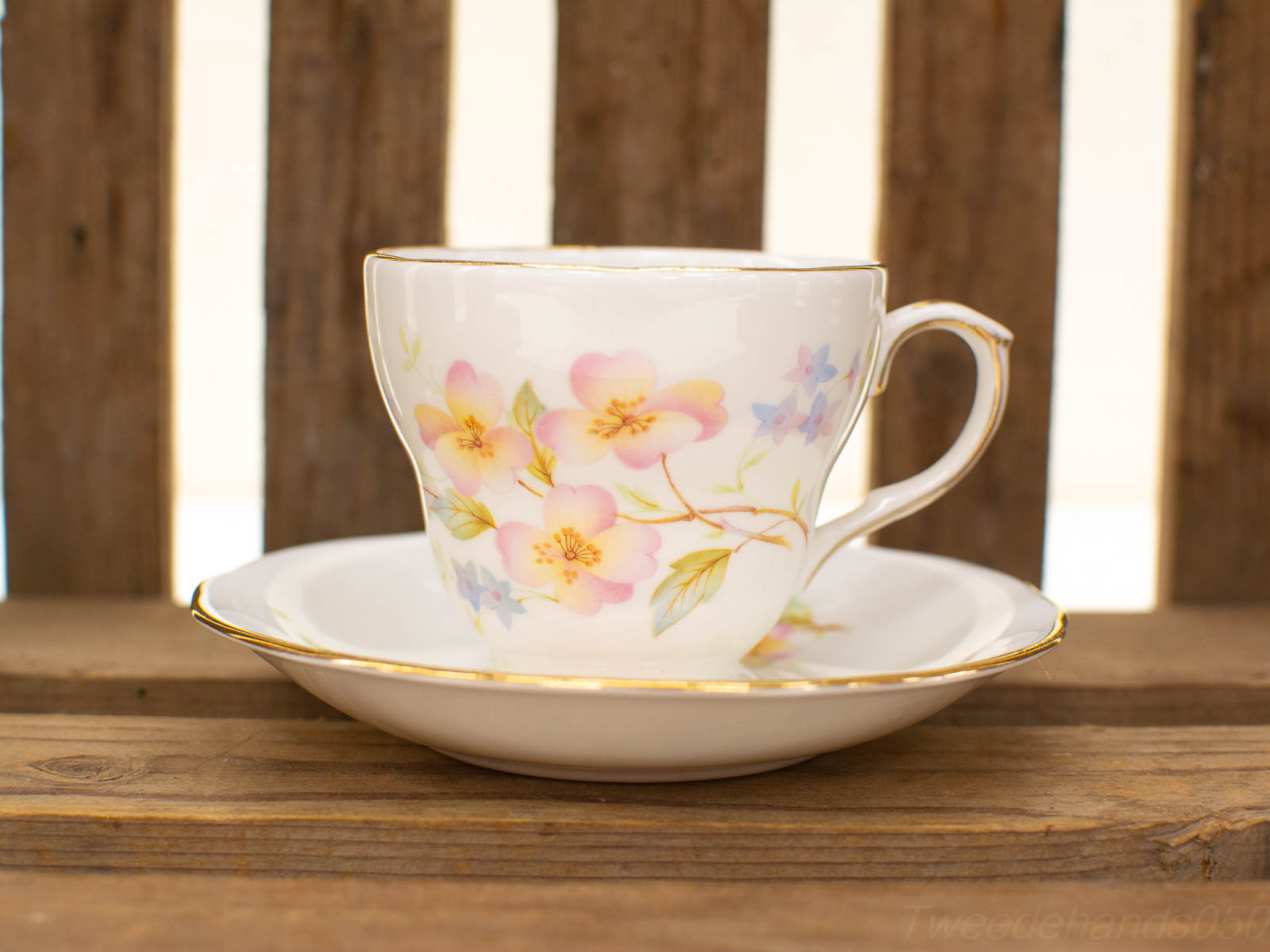 Vintage floral teacup set on rustic wooden background for cozy tea time moments.