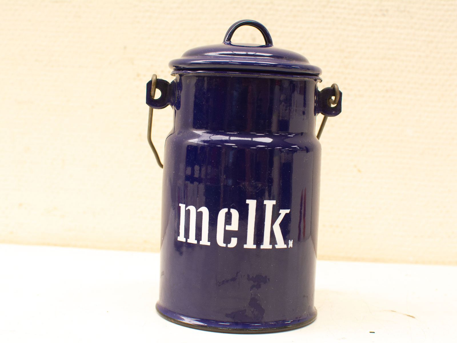 Charming vintage blue milk can with handles, perfect for rustic farmhouse decor.