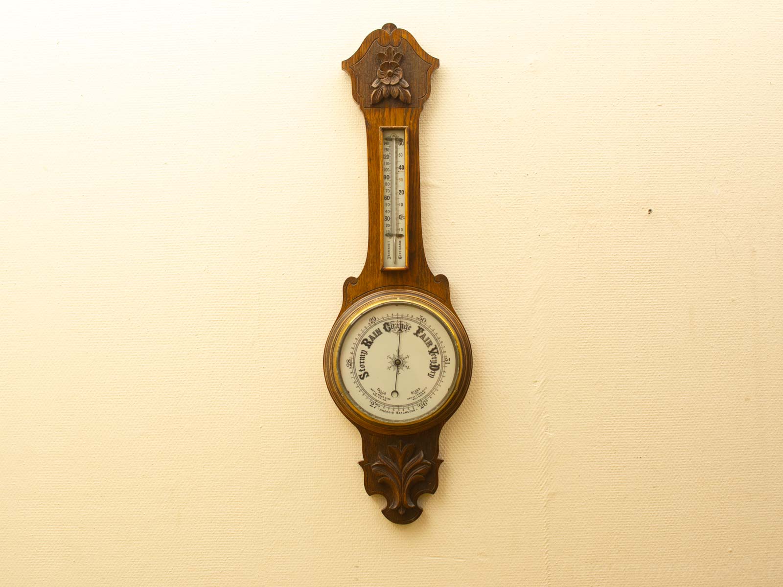 Vintage wooden barometer with artistic floral design, functional wall decor piece.