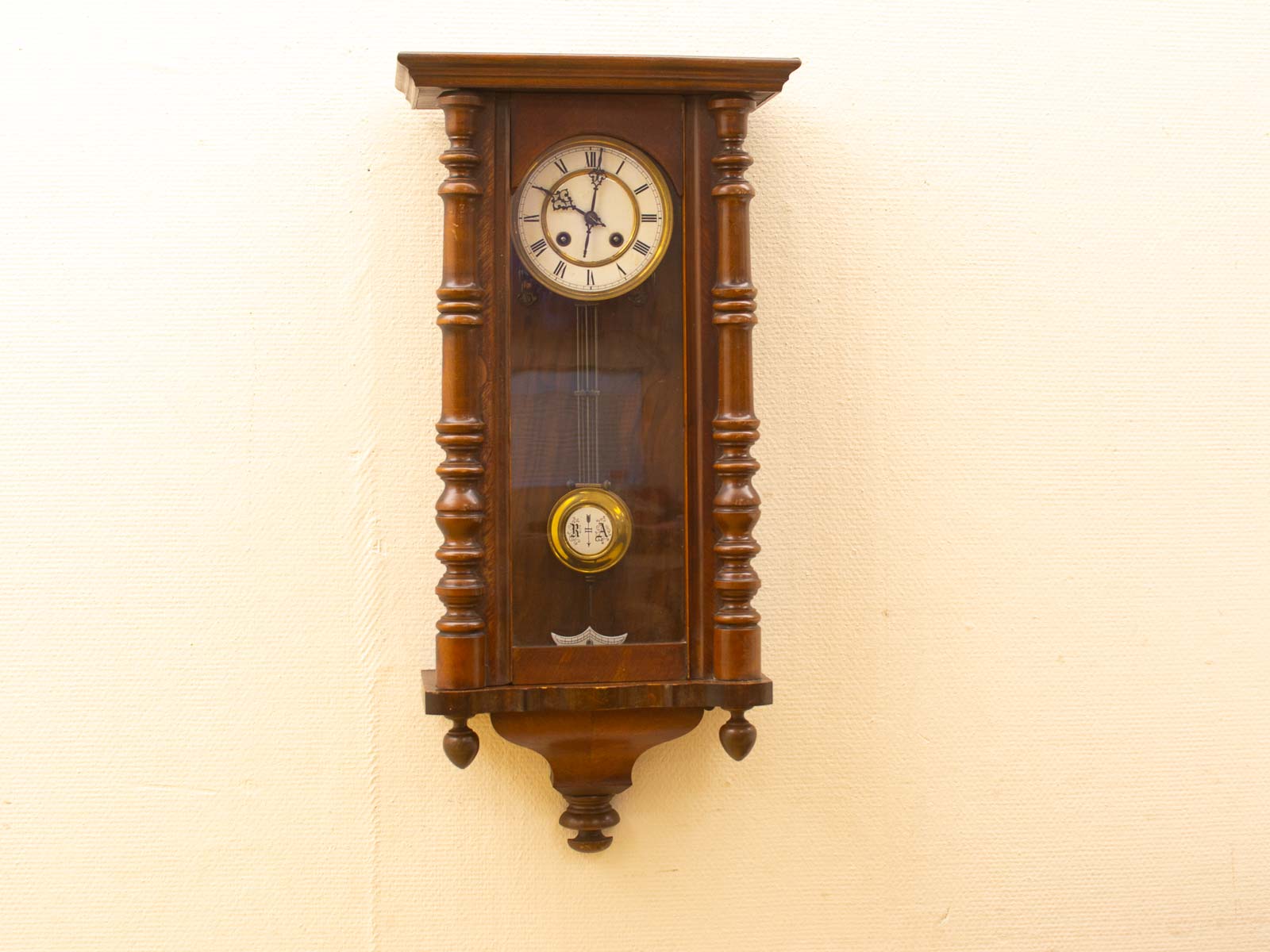 Vintage wooden wall clock with intricate detail work and integrated barometer.