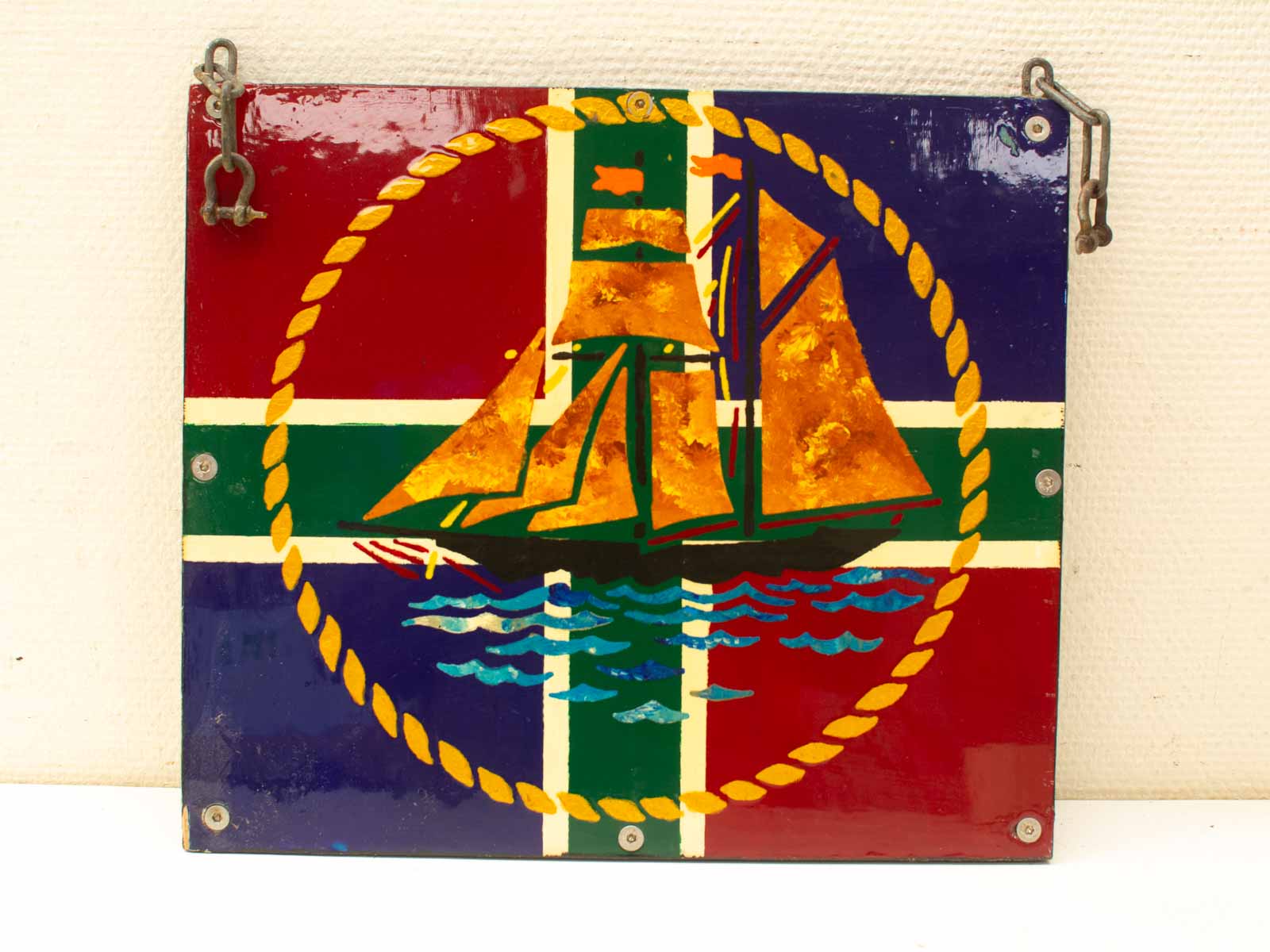 Colorful nautical plaque showcasing vibrant sailing ship against a geometric backdrop.