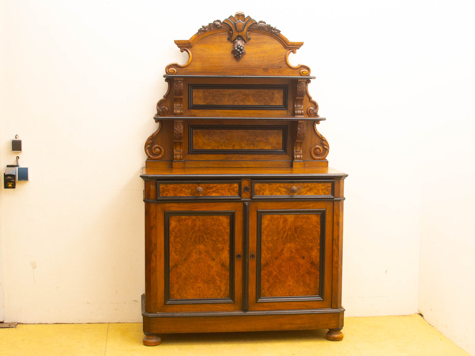 Vintage wooden cabinet with intricate grapevine motif and artistic finish, ideal for display and storage.