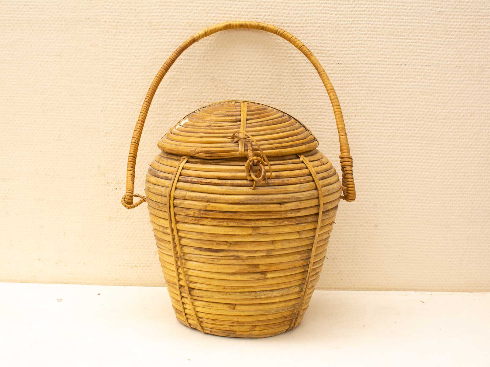 Elegant woven basket with lid and handle, perfect for storage or serving.