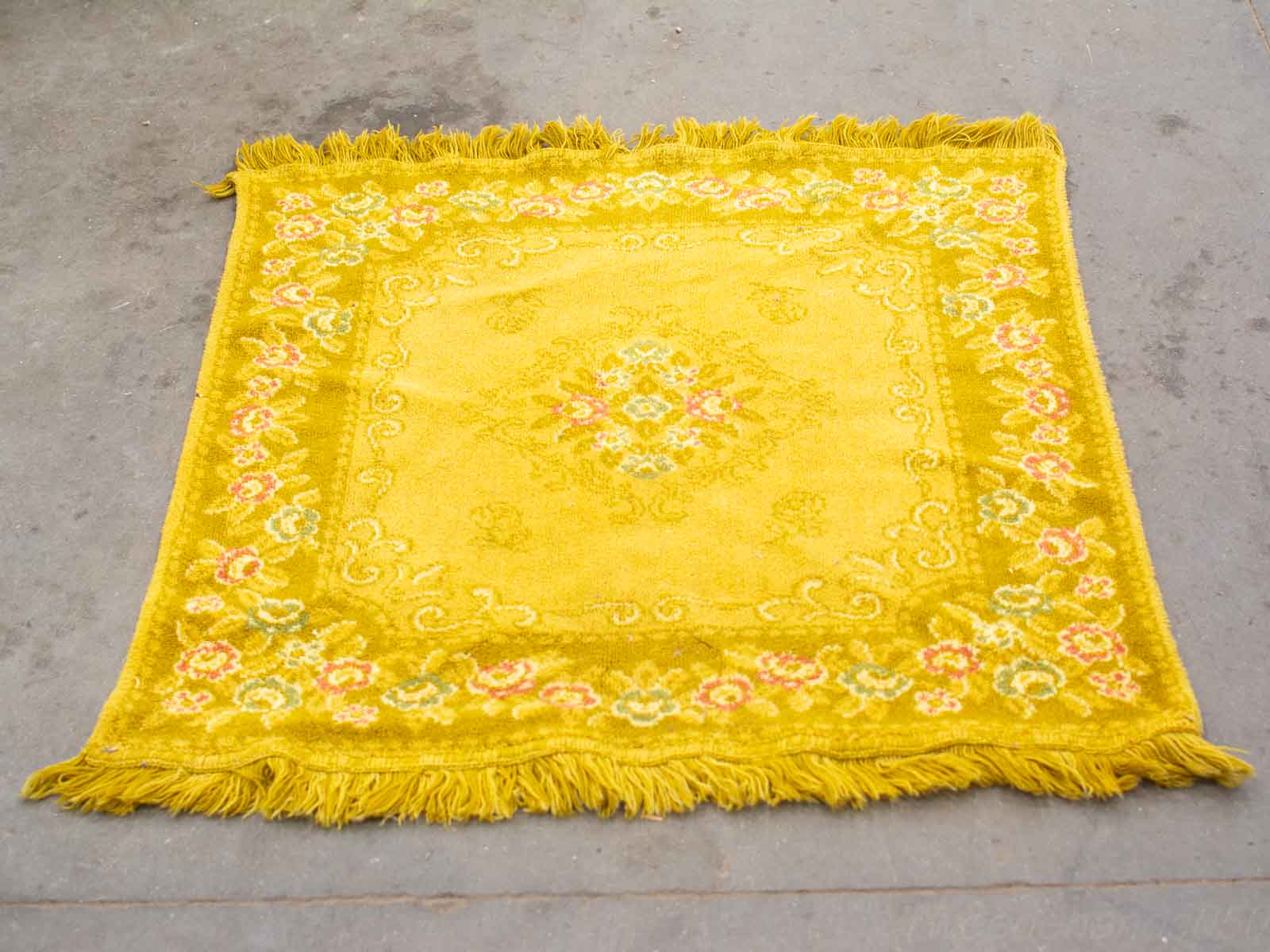 Vibrant yellow vintage rug with floral patterns, perfect for adding warmth to any room.