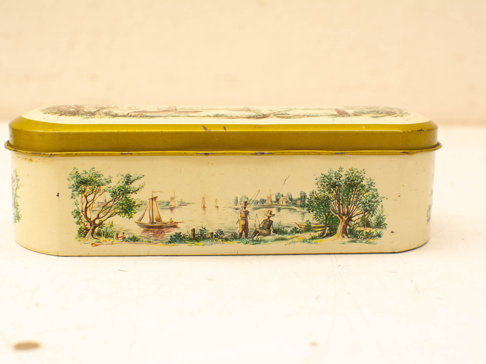 Charming vintage tin box with scenic lakeside design and vibrant yellow lid. Perfect for collectors!