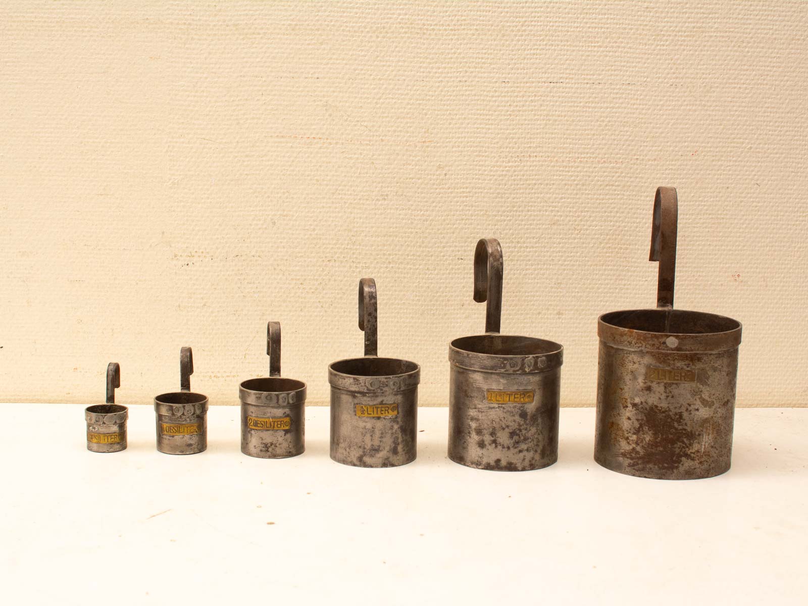 Vintage Metal Measuring Cups Set, ranging from 1 to 6 liters, ideal for cooking and baking.