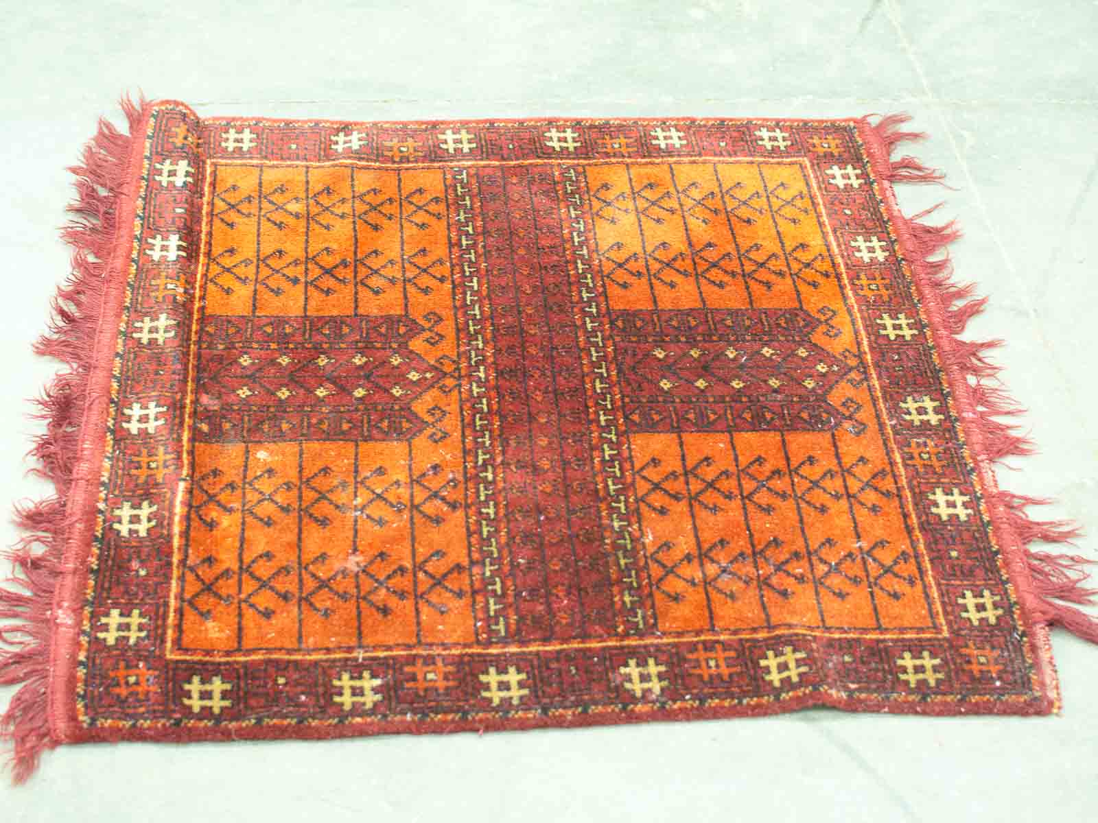 Vibrant vintage geometric rug in warm orange and red, perfect for stylish home decor.