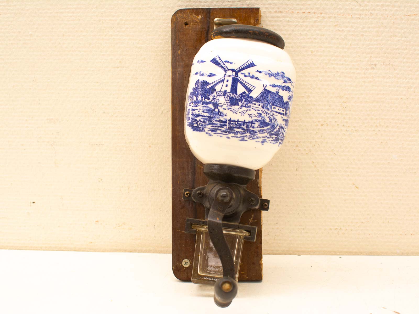 Vintage Dutch-style ceramic drink dispenser with wooden mount and windmill design.