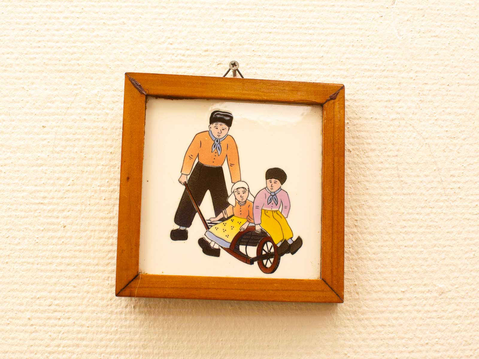 Delightful illustration of children enjoying a cart ride with caregiver in a warm wooden frame