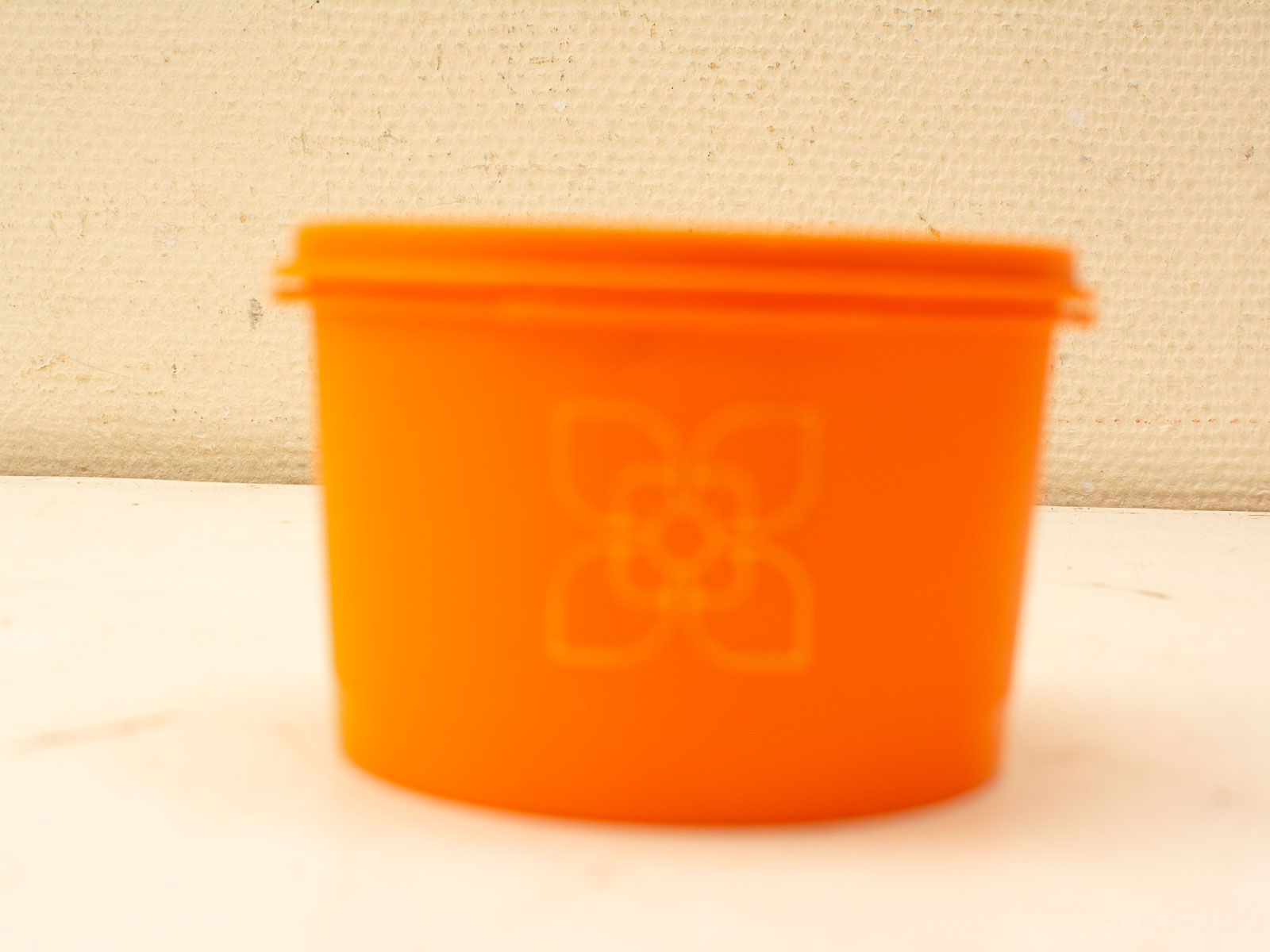 Vibrant orange storage container with floral design, perfect for storage or decoration.