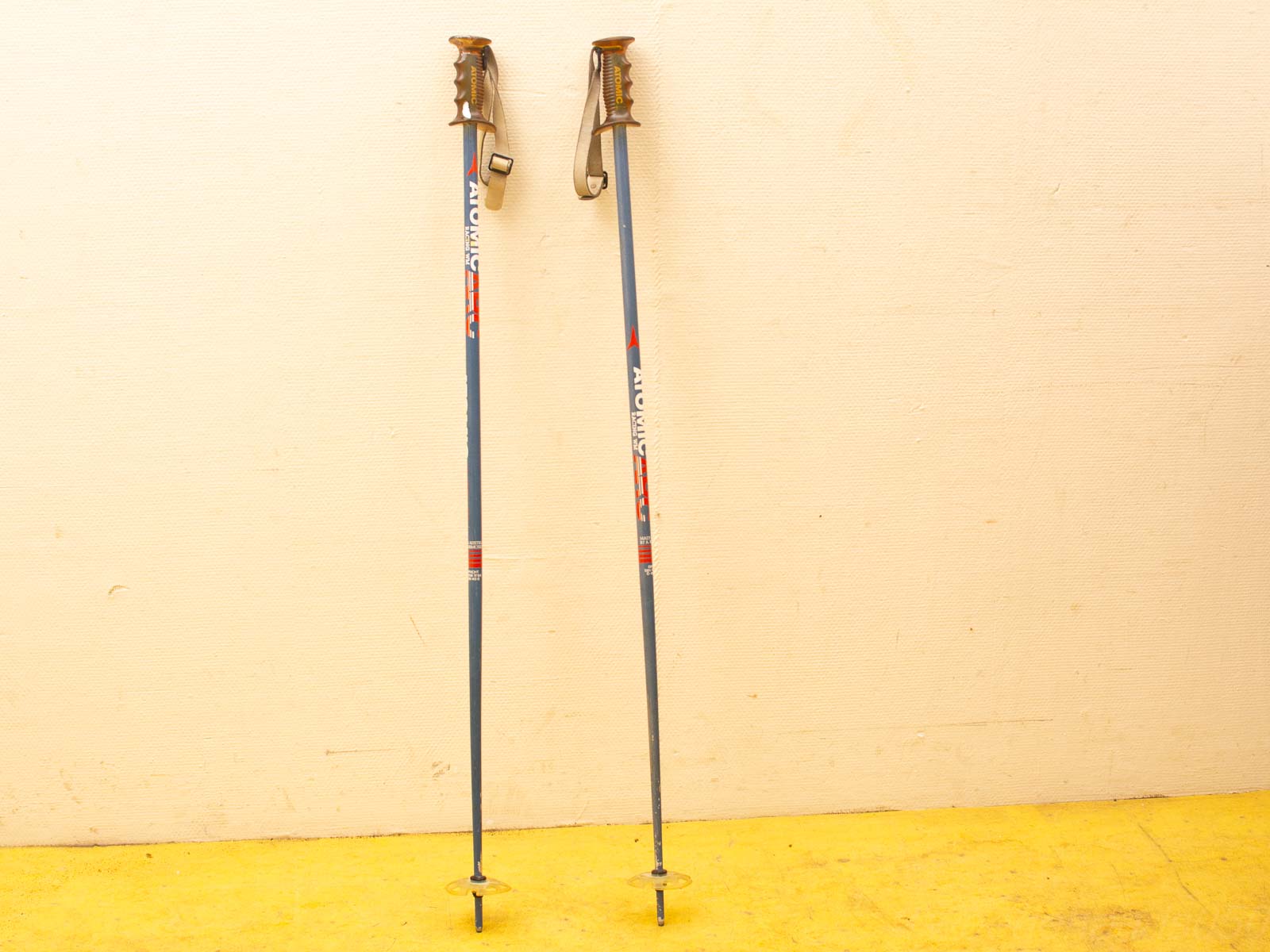 Lightweight blue, red, and white ski poles with ergonomic grips and adjustable straps for optimal performance.