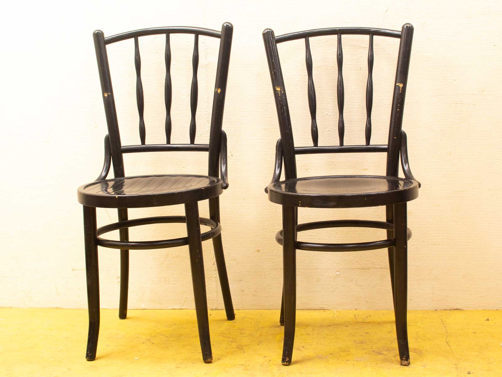 Timeless vintage black wooden chairs with character, perfect for any stylish interior space.