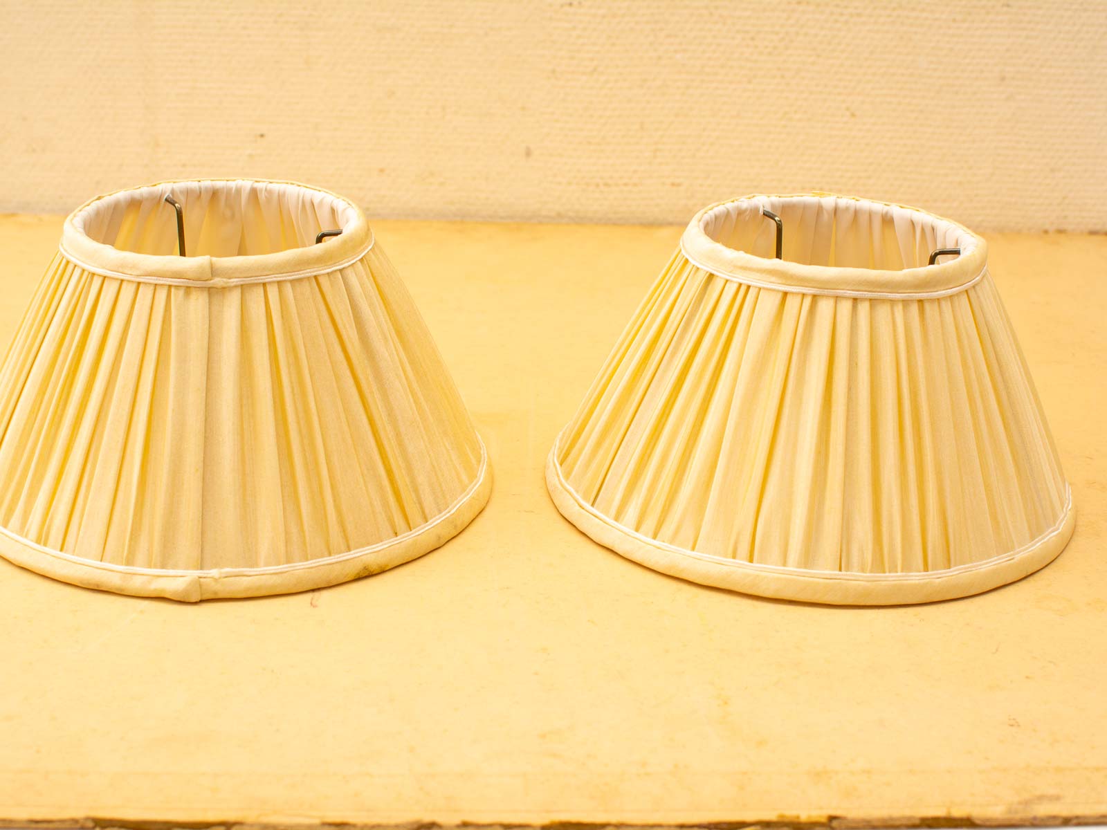 Classic cream-yellow pleated lampshades adding cozy warmth to any home decor style.