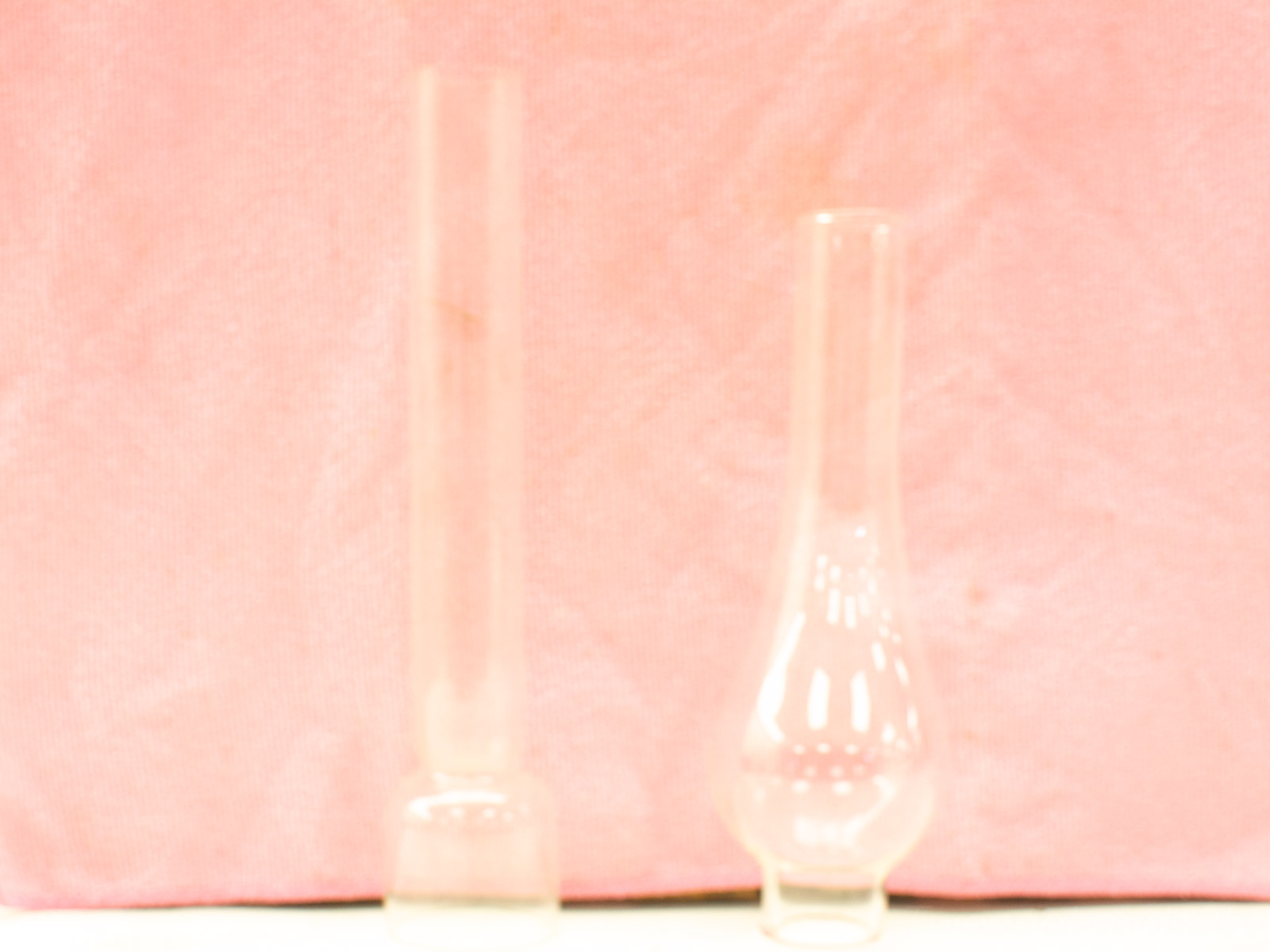 Glass lab vessels against playful pink background, showcasing the beauty of science.