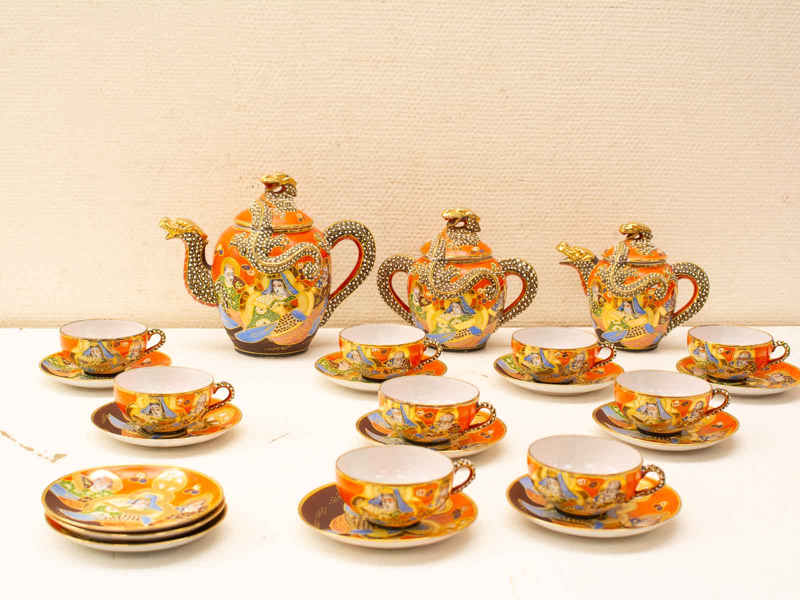 Vibrant vintage tea set with serpent design, featuring intricate artwork and elegant gold accents.