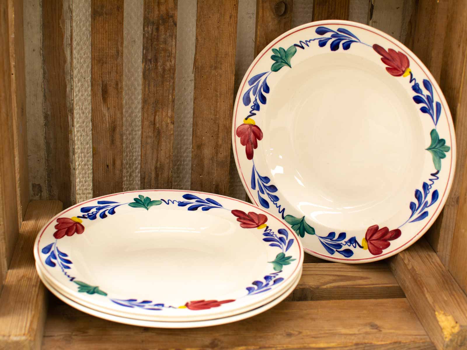 Vintage floral plates in rustic crate add charm to any kitchen or dining room.